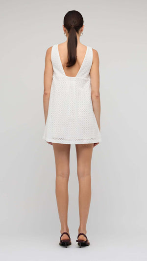 Back view of the White Broderie Mini Shift Dress showcasing the deep V-back design and sleeveless style.
