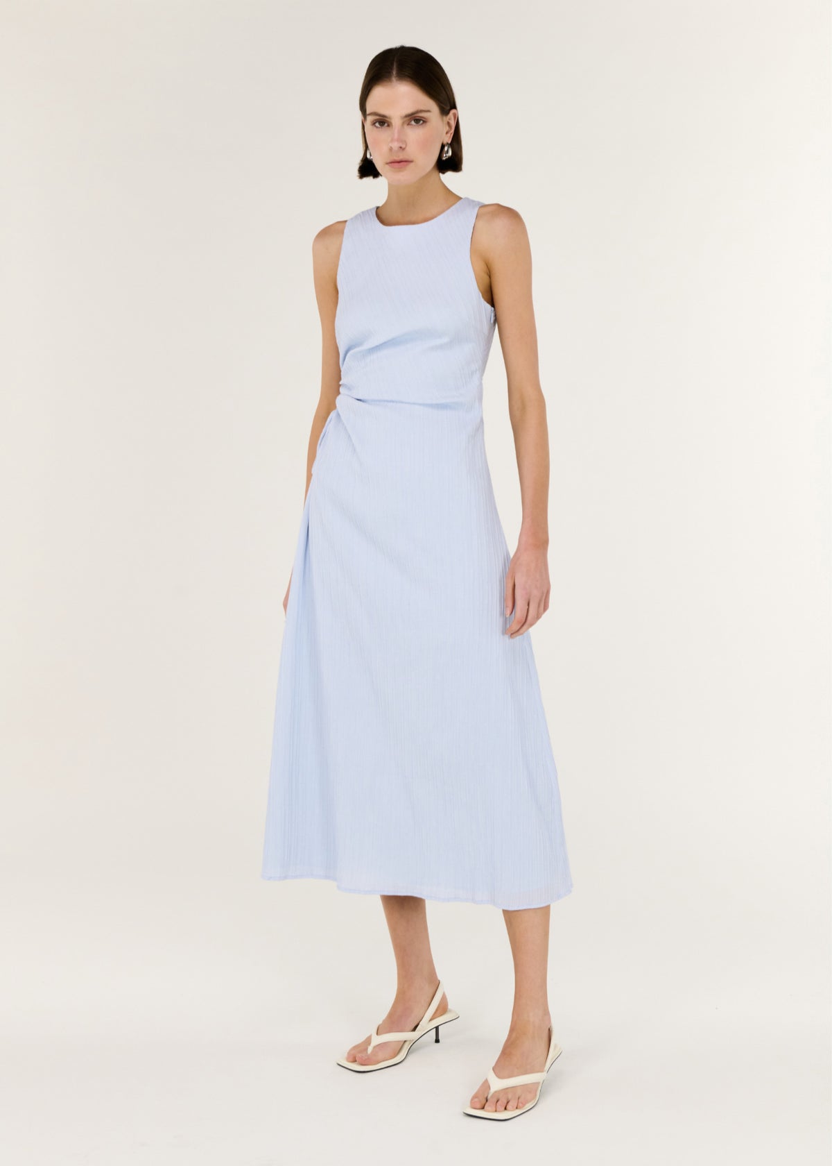 Model wearing Baby Blue Cotton Textured Cut Out Midi Dress, showing a sleeveless midi silhouette and a subtle side cut-out detail.