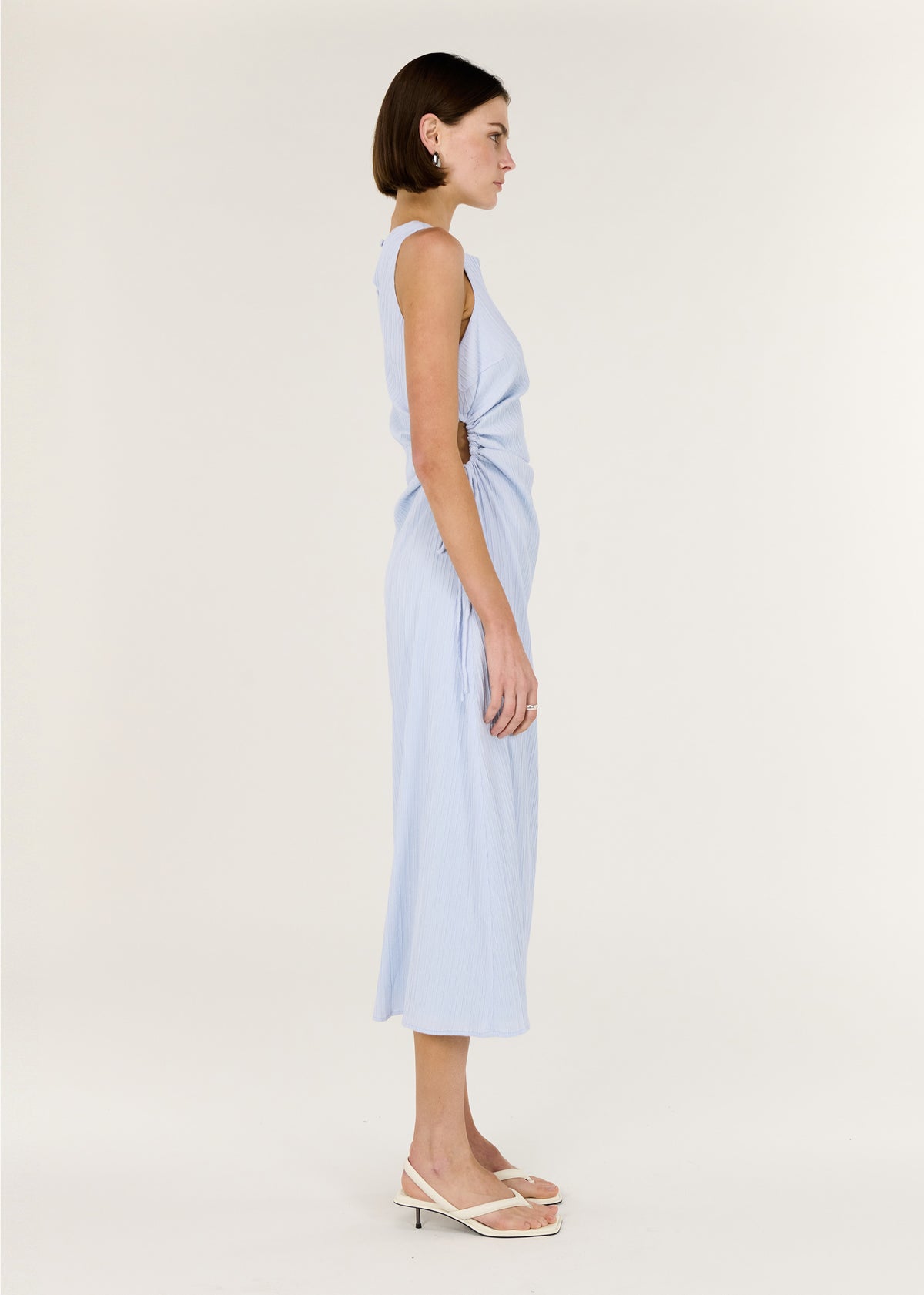 Side view of the Baby Blue Cotton Textured Cut Out Midi Dress, showing a soft ruching through the waist and a ribbed stretch fabrication.