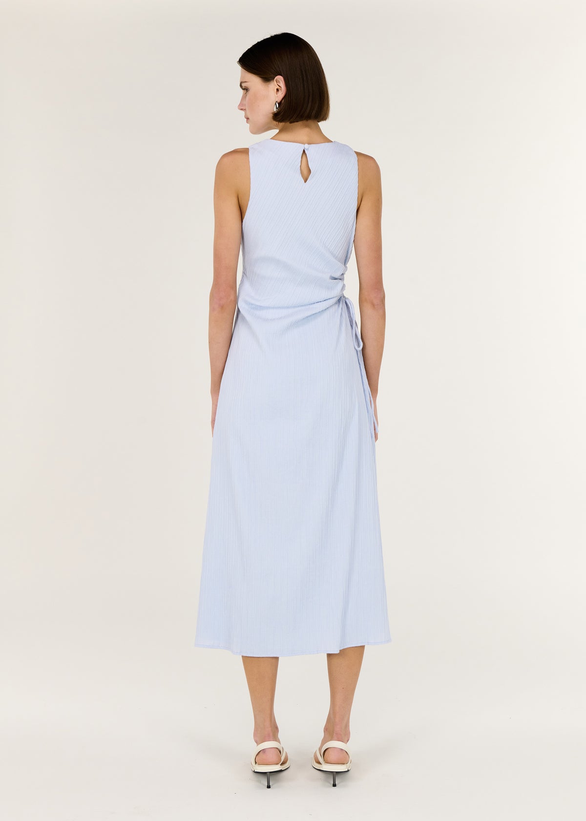 Back view of the Baby Blue Cotton Textured Cut Out Midi Dress with a sleeveless midi silhouette and a subtle side cut-out detail.