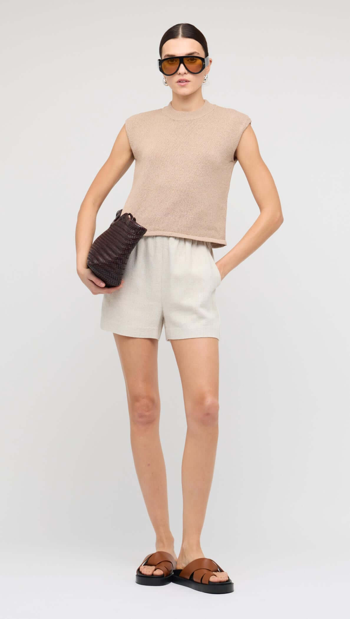 Beige Sleeveless Knit Top styled with tailored linen shorts and accessories.