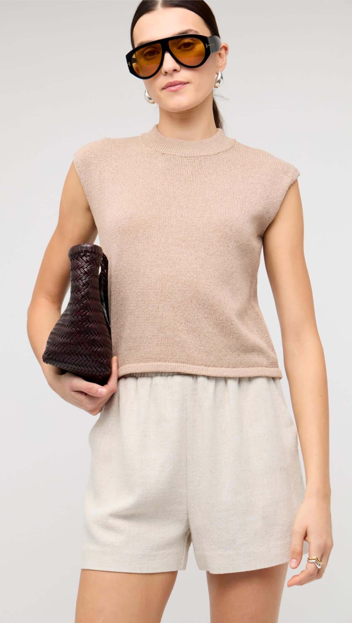Beige Sleeveless Knit Top styled with tailored linen shorts and accessories.