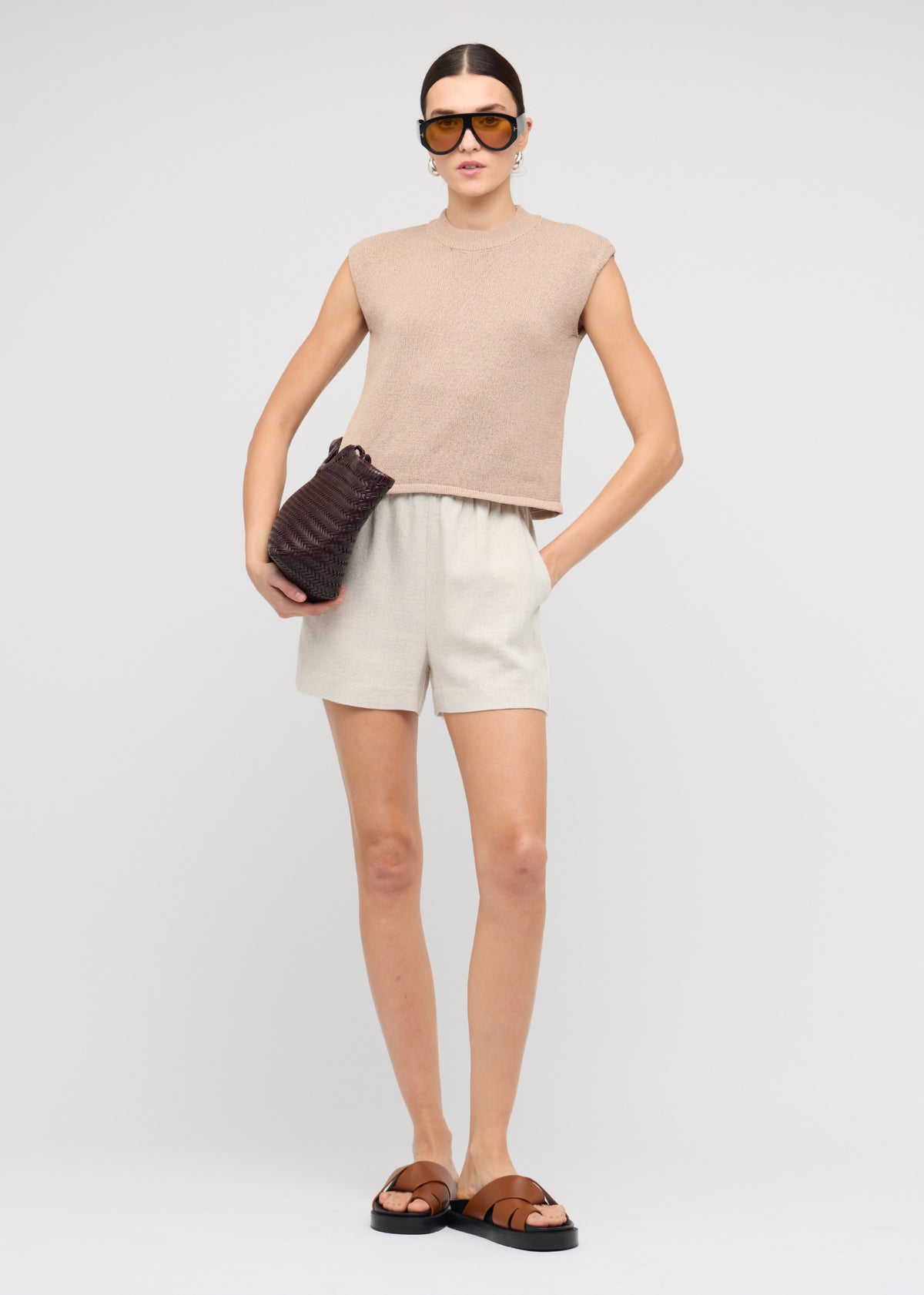 Model wearing Beige Sleeveless Knit Top with a sleeveless cut and a crew neckline.