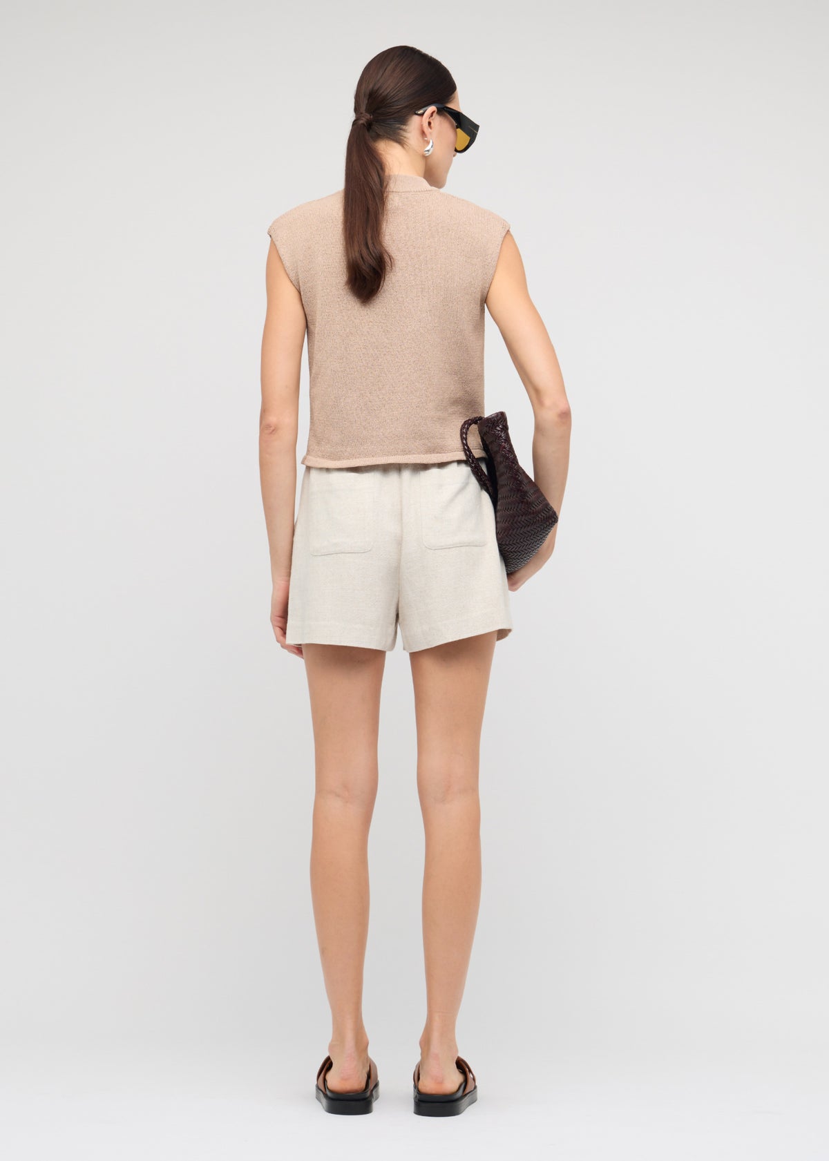 Back view of the Beige Sleeveless Knit Top with a sleeveless cut and a crew neckline.