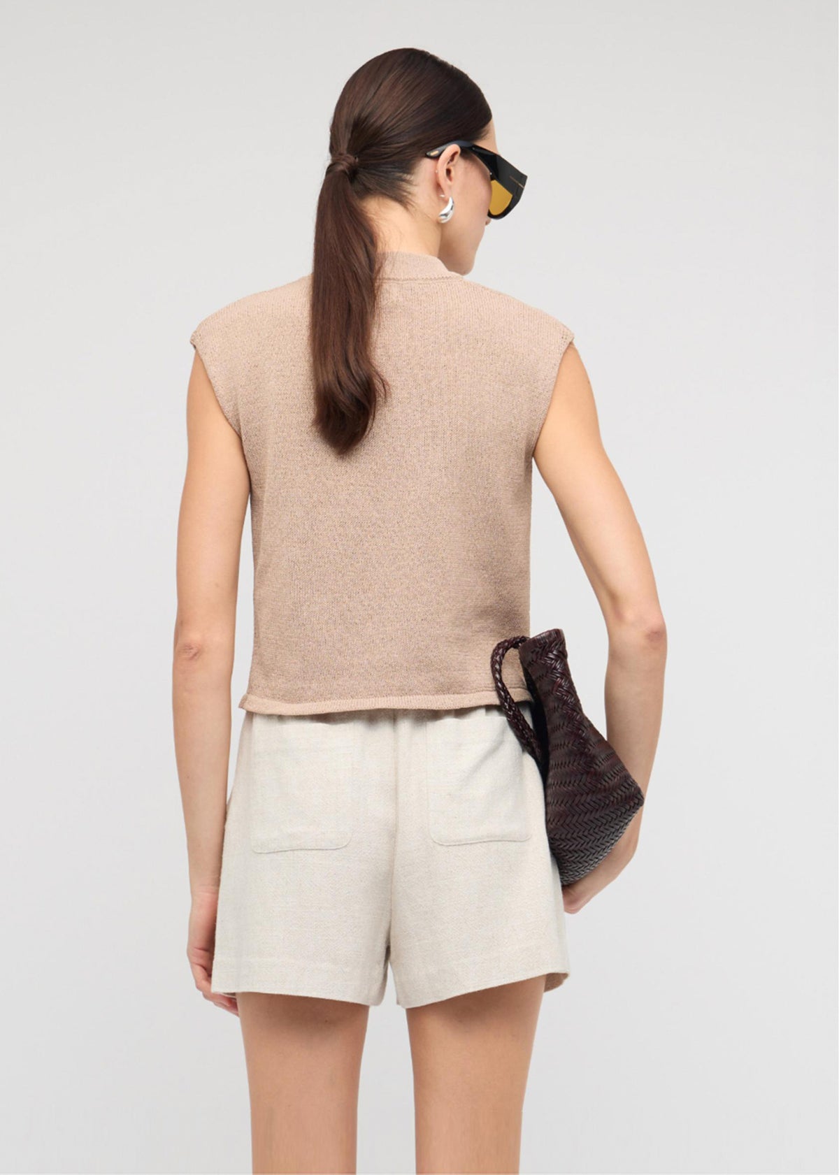 Back view of the Beige Sleeveless Knit Top, showing a sleeveless cut and a crew neckline.