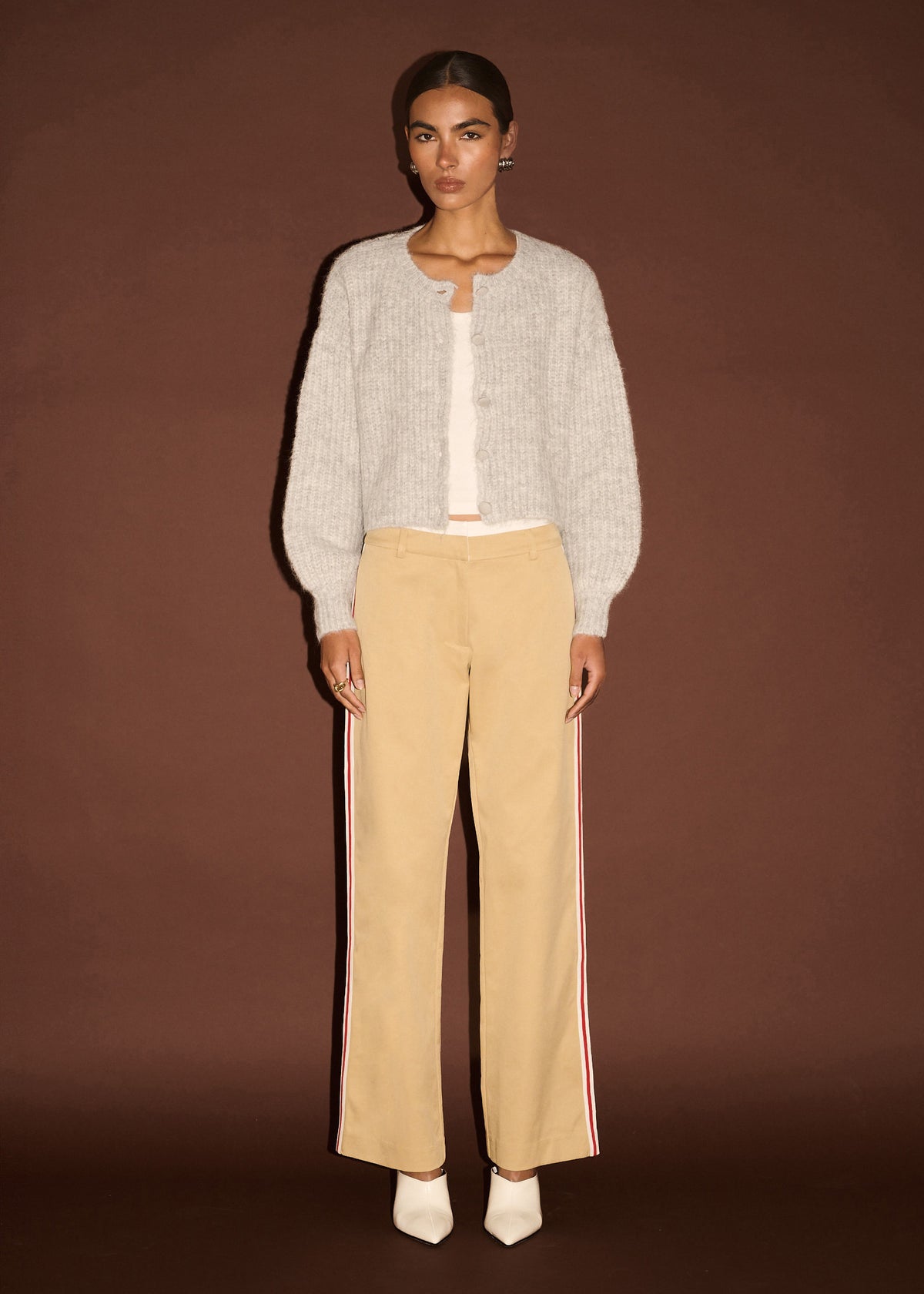 Model wearing Beige Striped Contrast Waist Pants with a red side stripe detail and a smooth woven fabrication.