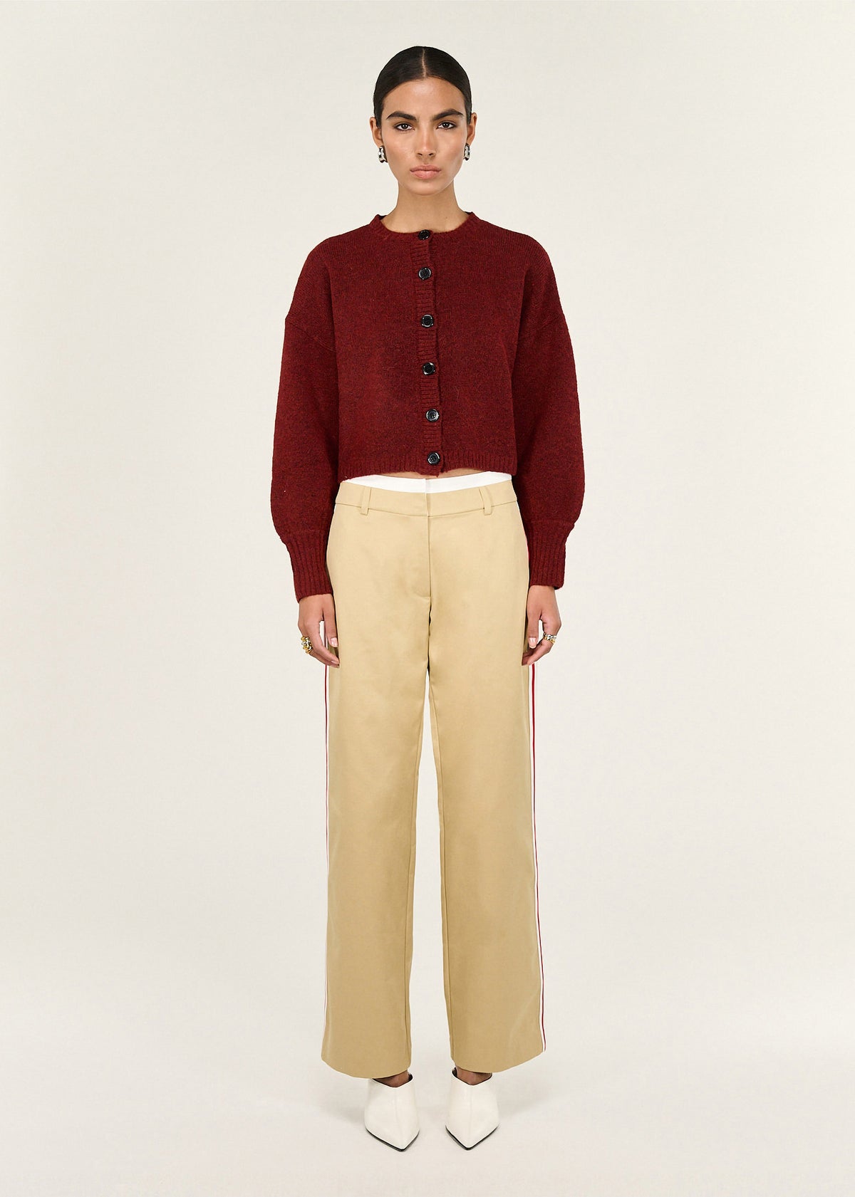 Model wearing Beige Striped Contrast Waist Pants, showing a contrast white waist band and a red side stripe detail.