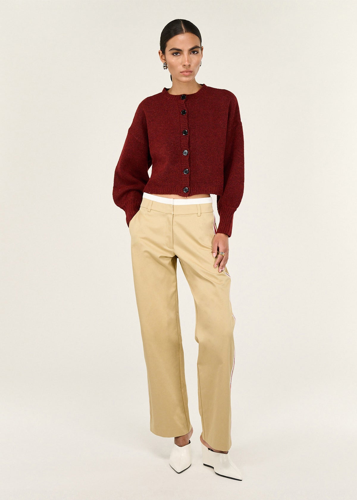 Model wearing Beige Striped Contrast Waist Pants with a smooth woven fabrication and a clean tailored finish, turned to the side.