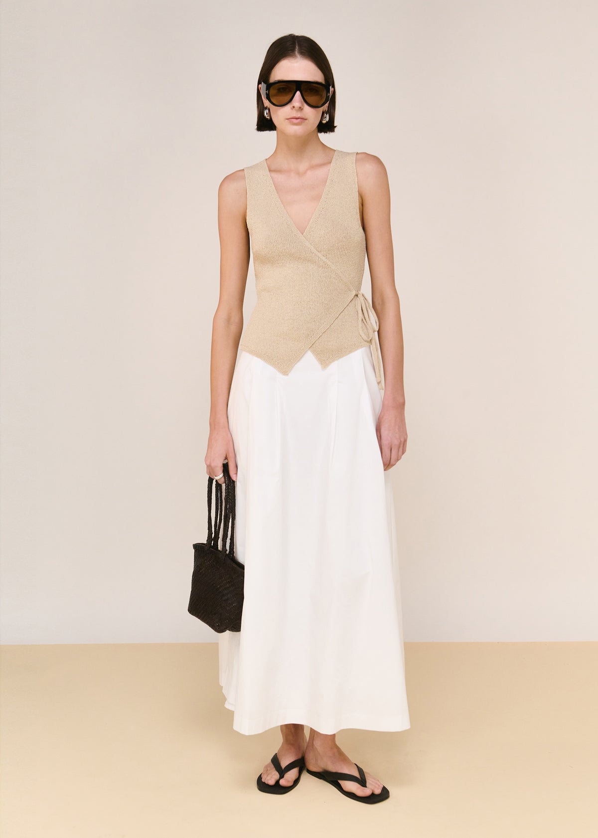 Model wearing Beige V-neck Wrap Knit Top with a lightweight and breathable feel, photographed against a beige studio backdrop.