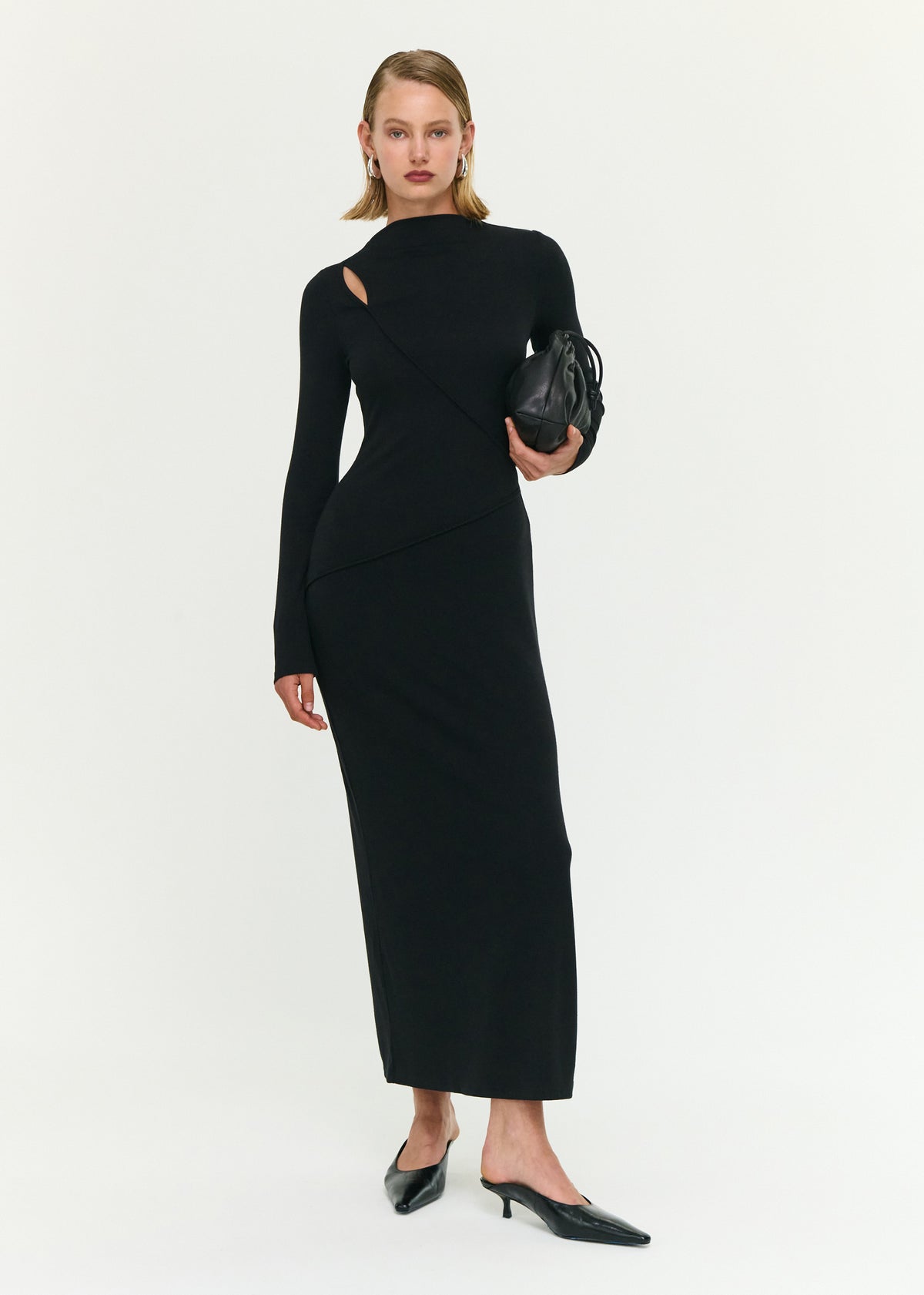 Model wearing Black Asymmetric Seam Detail Midi Dress with an angled seam detailing and long sleeves, turned to the side.