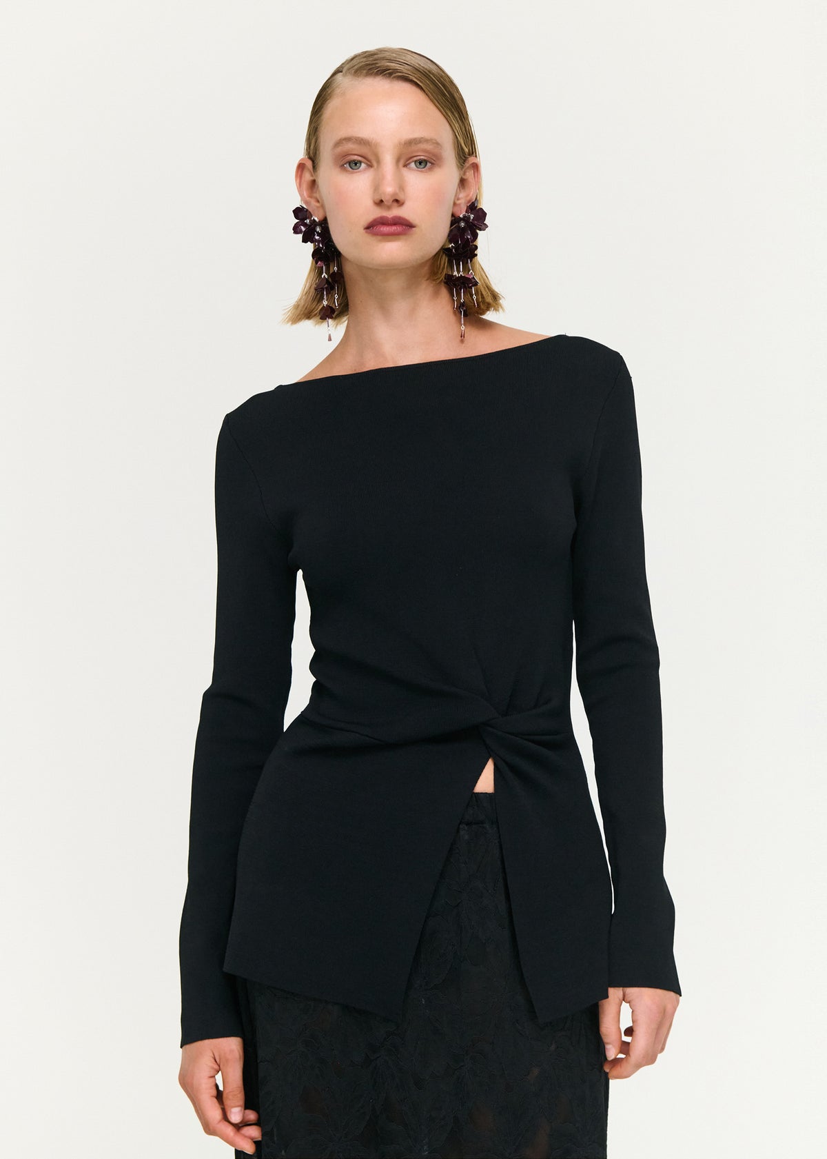 Close-up of the Black Boat Neck Twist Knit Top, showing a boat neckline and long sleeves.