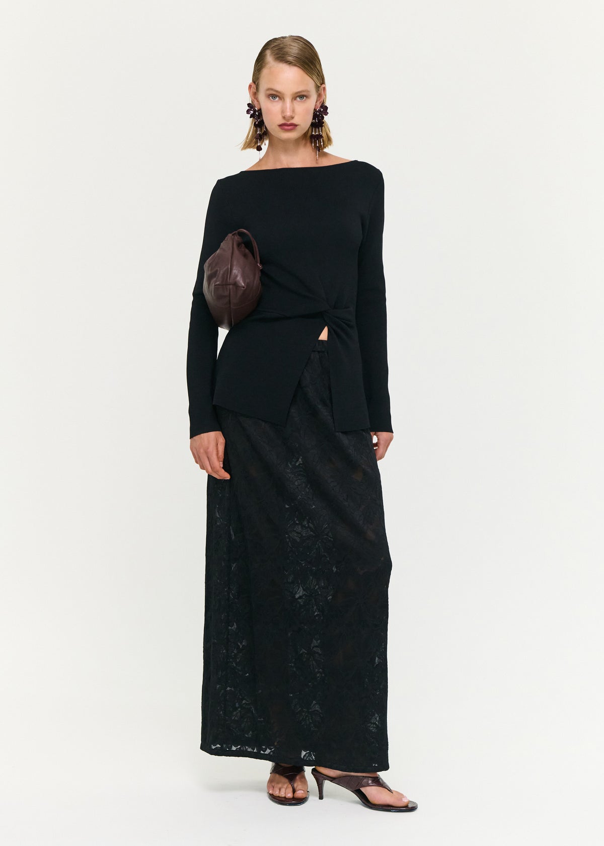 Model wearing Black Boat Neck Twist Knit Top with a boat neckline and long sleeves.