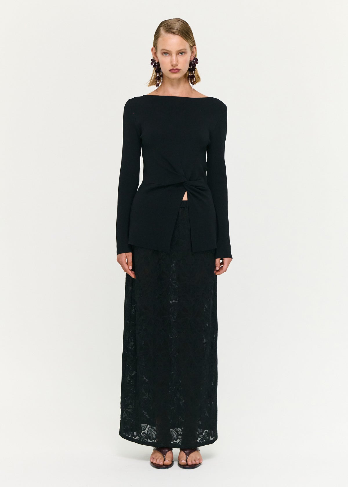Model wearing Black Boat Neck Twist Knit Top with a soft stretch knit fabrication and a fitted silhouette.