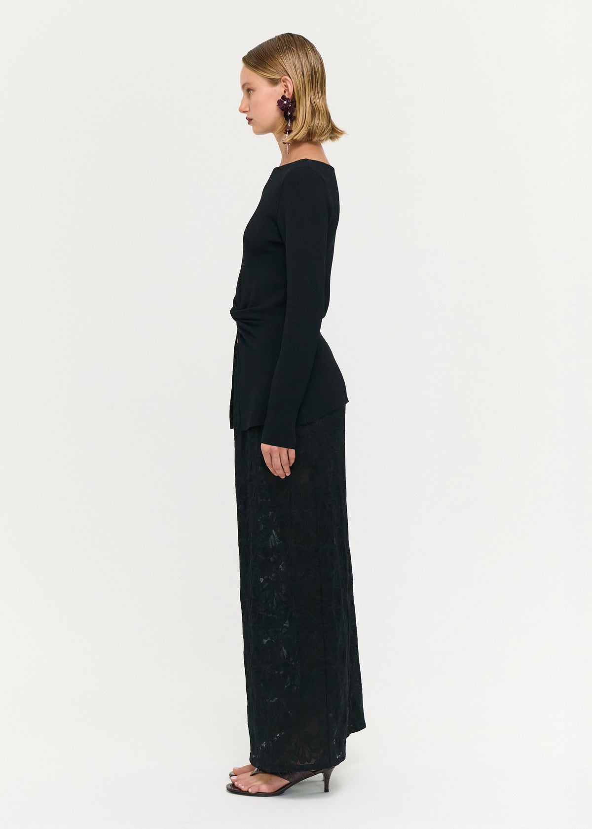 Side view of the Black Boat Neck Twist Knit Top, showing a boat neckline and long sleeves.