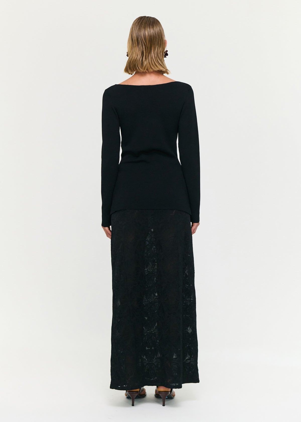 Back view of the Black Boat Neck Twist Knit Top with a soft stretch knit fabrication and a fitted silhouette.