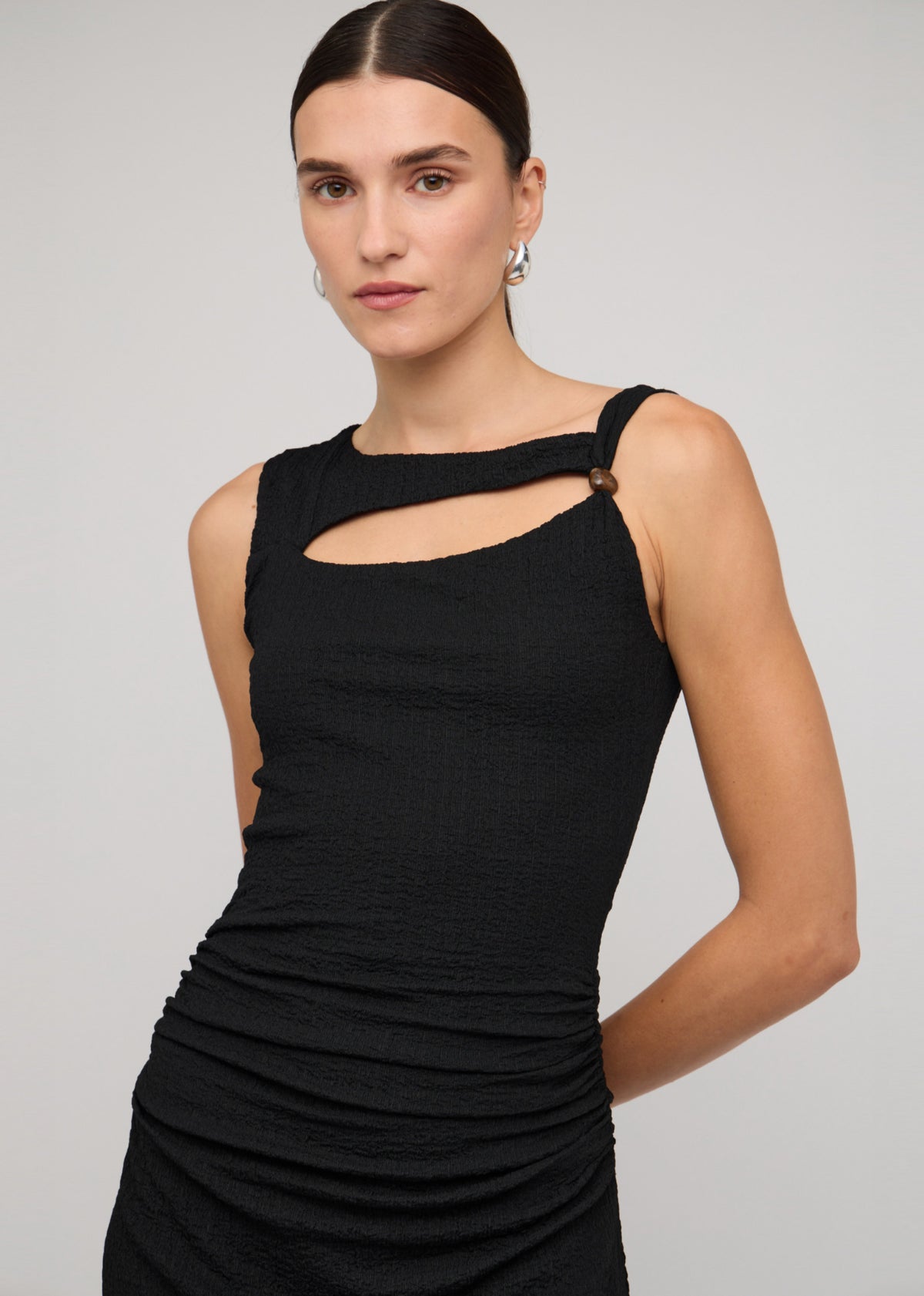 Close-up of the Black Cut Out Ruched A-Line Midi Dress With Bead Detail, showing an asymmetric neckline with cut-out detail.