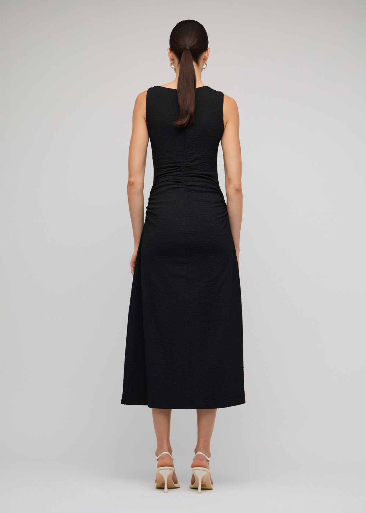 Back view of the Black Cut Out Ruched A-Line Midi Dress With Bead Detail with a black and an asymmetric neckline with cut-out detail.