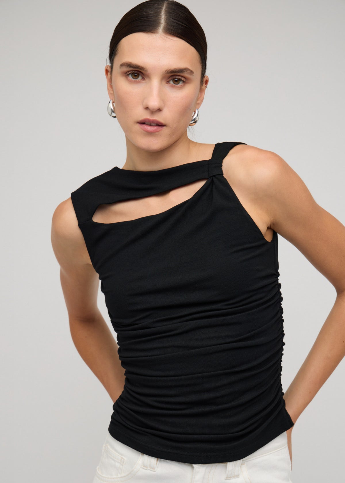 Close-up of the Black Cut Out Ruched Top With Bead Detail, showing an asymmetrical neckline with cut-out detail and a sleeveless cut.