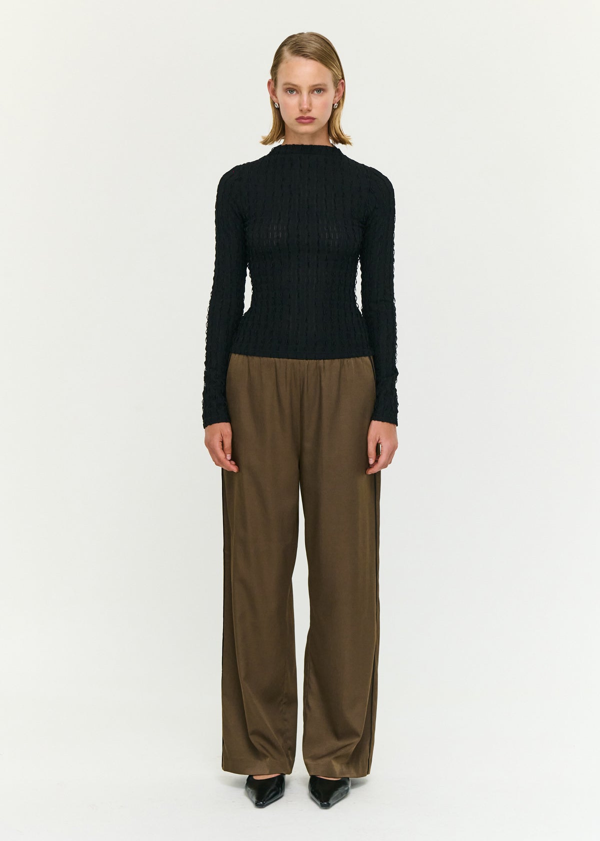 Model wearing Black High Neck Crinkle Stitch Top, showing a semi-sheer finish and a lightweight feel.