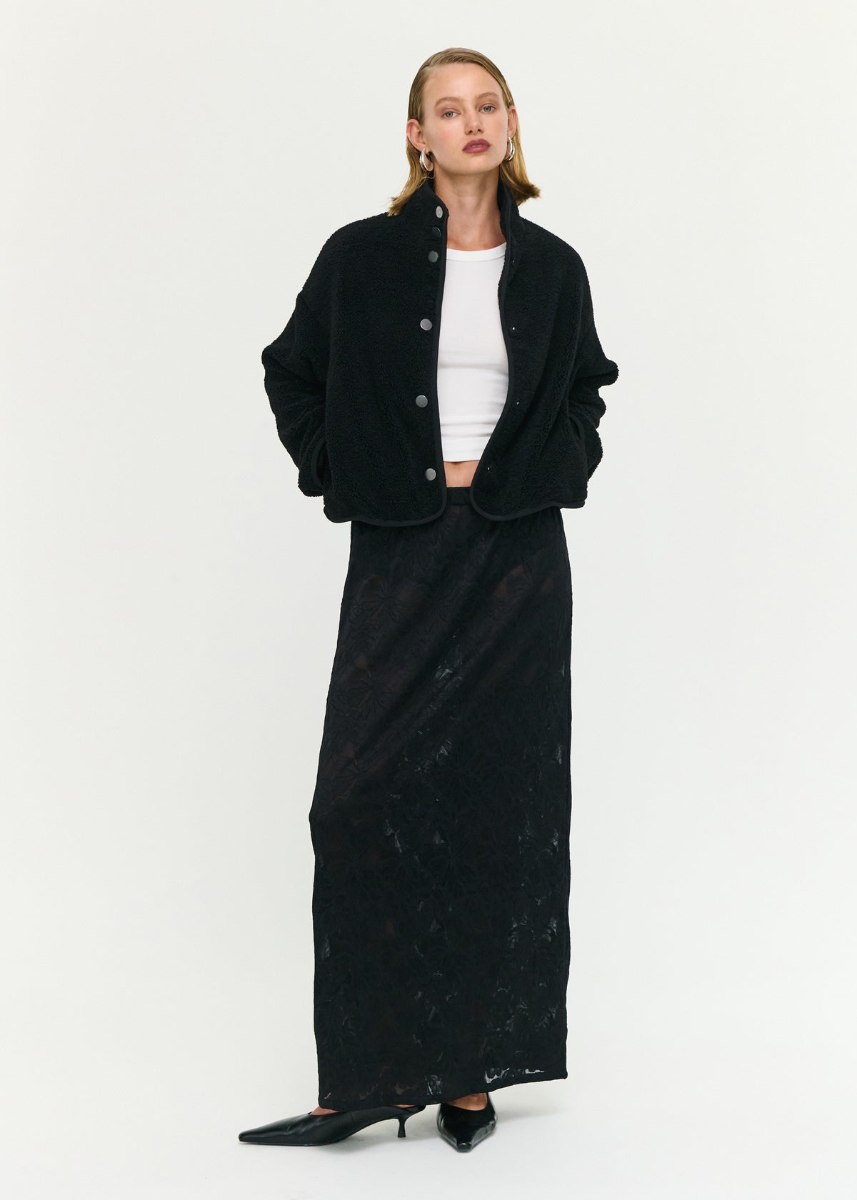 Model wearing Black High Neck Cropped Sherpa Jacket with a snap button front closure and a stand collar neckline.