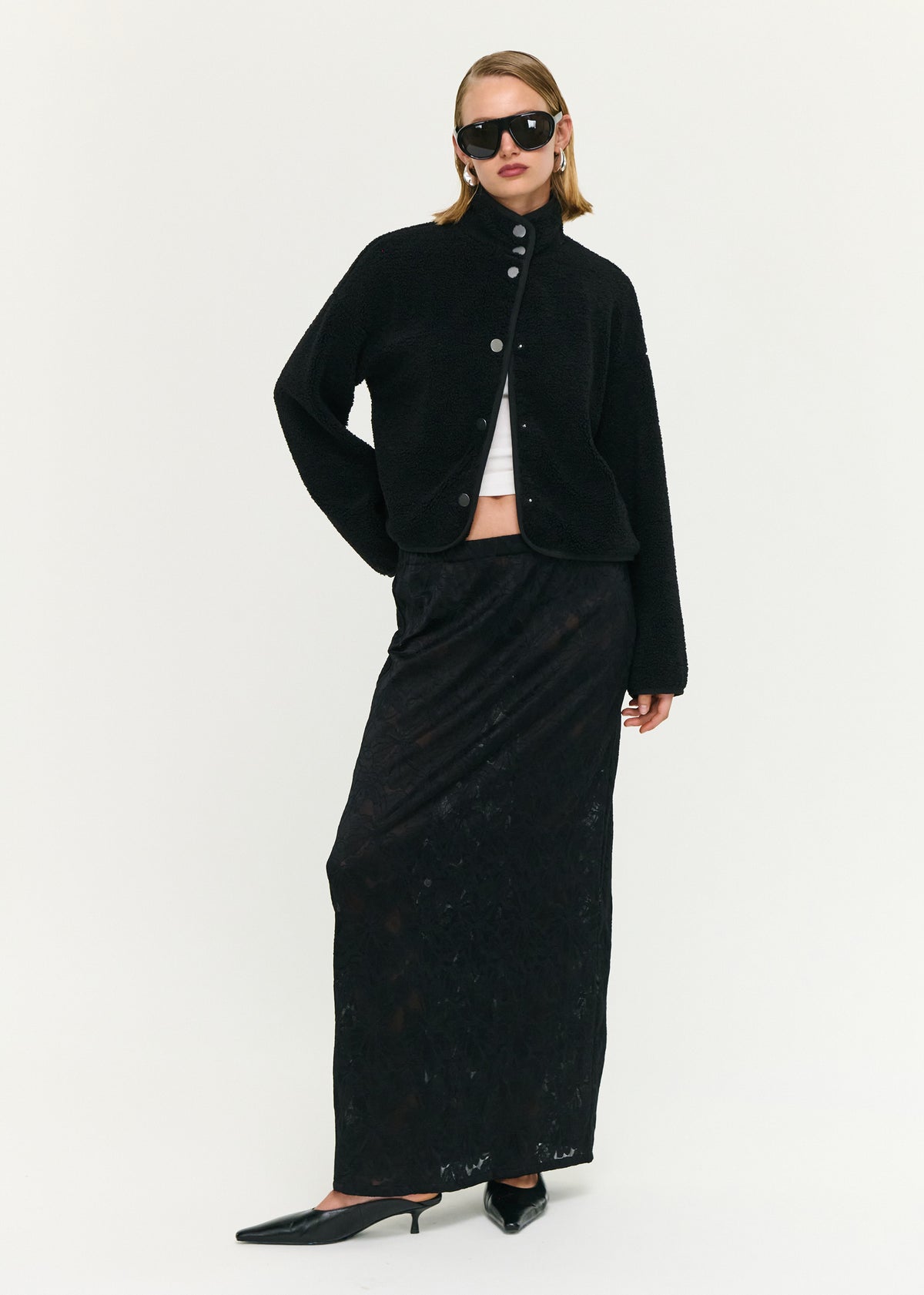 Model wearing Black High Neck Cropped Sherpa Jacket, showing a clean, minimal finish and long sleeves.