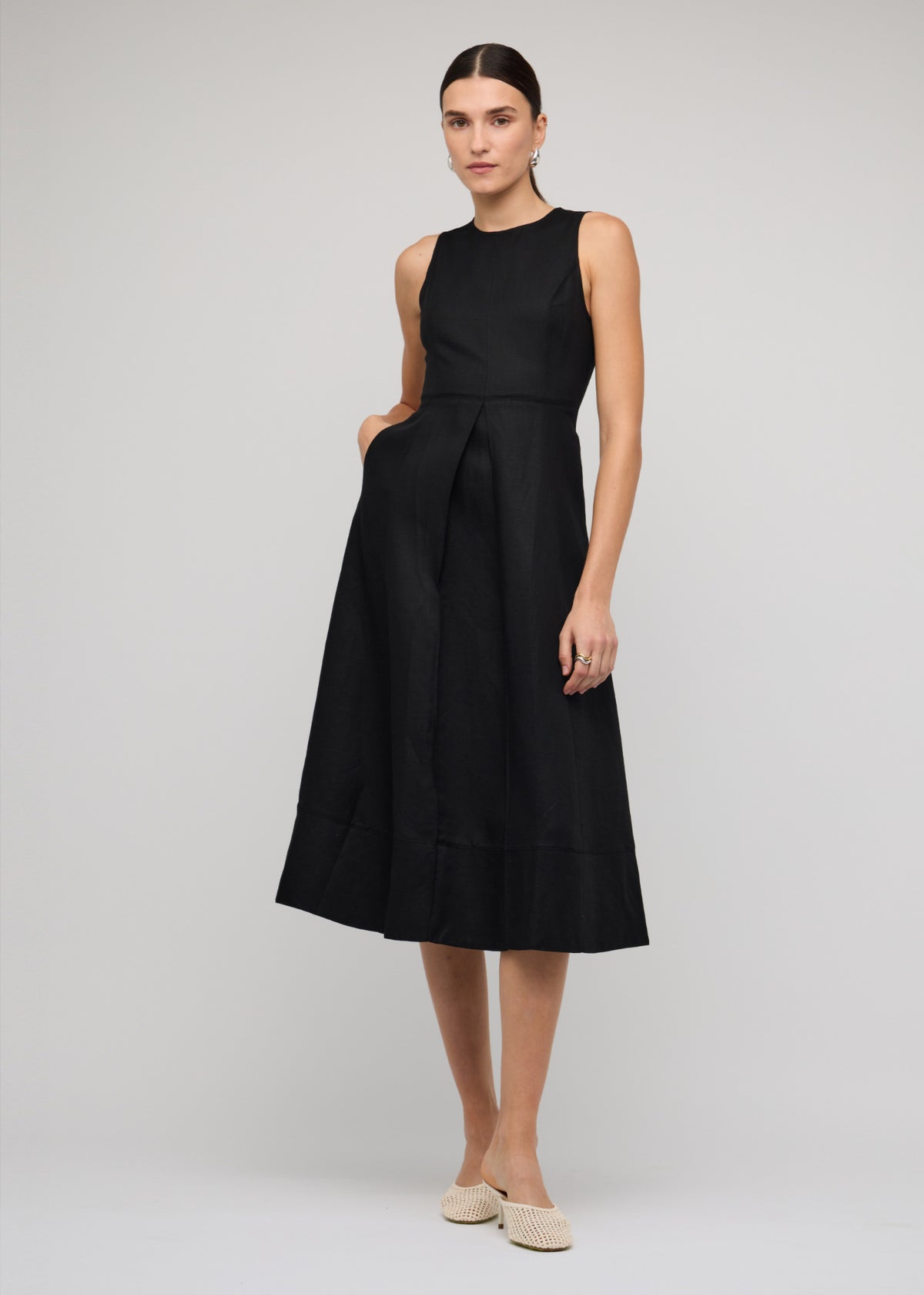 Model wearing Black Linen A-Line Midi Dress with a fitted sleeveless bodice with round neckline and a seam panel detailing.