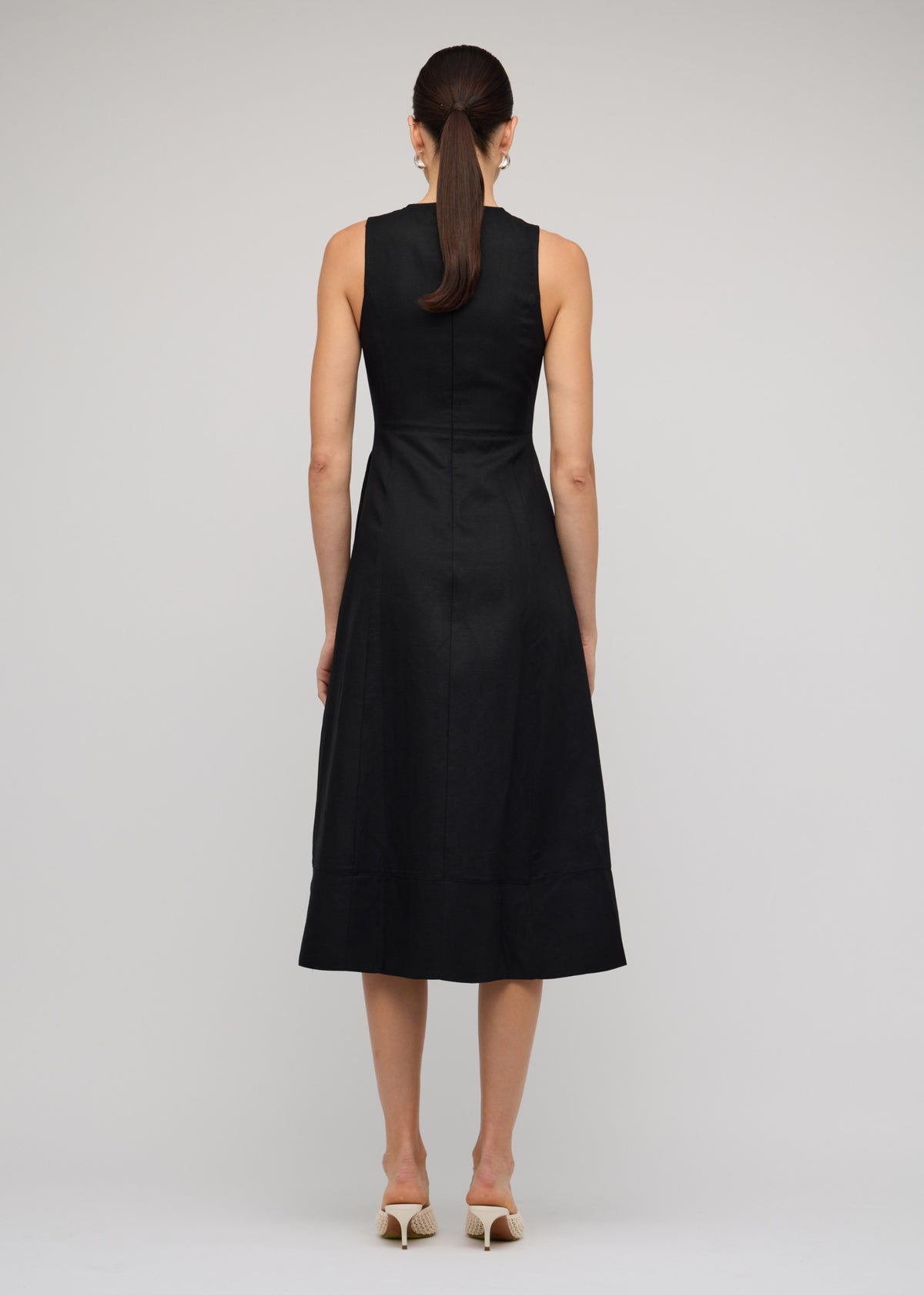 Back view of the Black Linen A-Line Midi Dress with a concealed back zip closure and a fitted sleeveless bodice with round neckline.