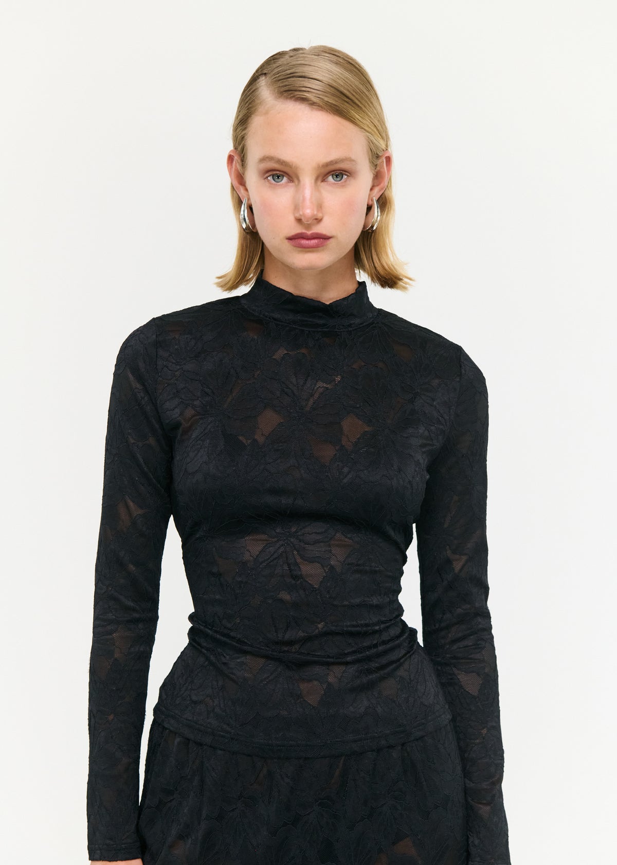 Close-up of the Black Sheer Lace Long Sleeve Top, showing a high neckline and long sleeves.