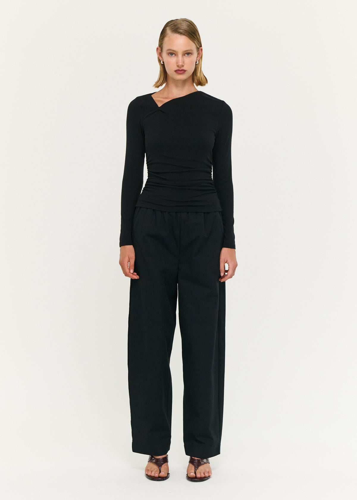 Model wearing Black Soft Jersey Twist Neck Top, showing a twist detail at shoulder and a clean, streamlined finish.