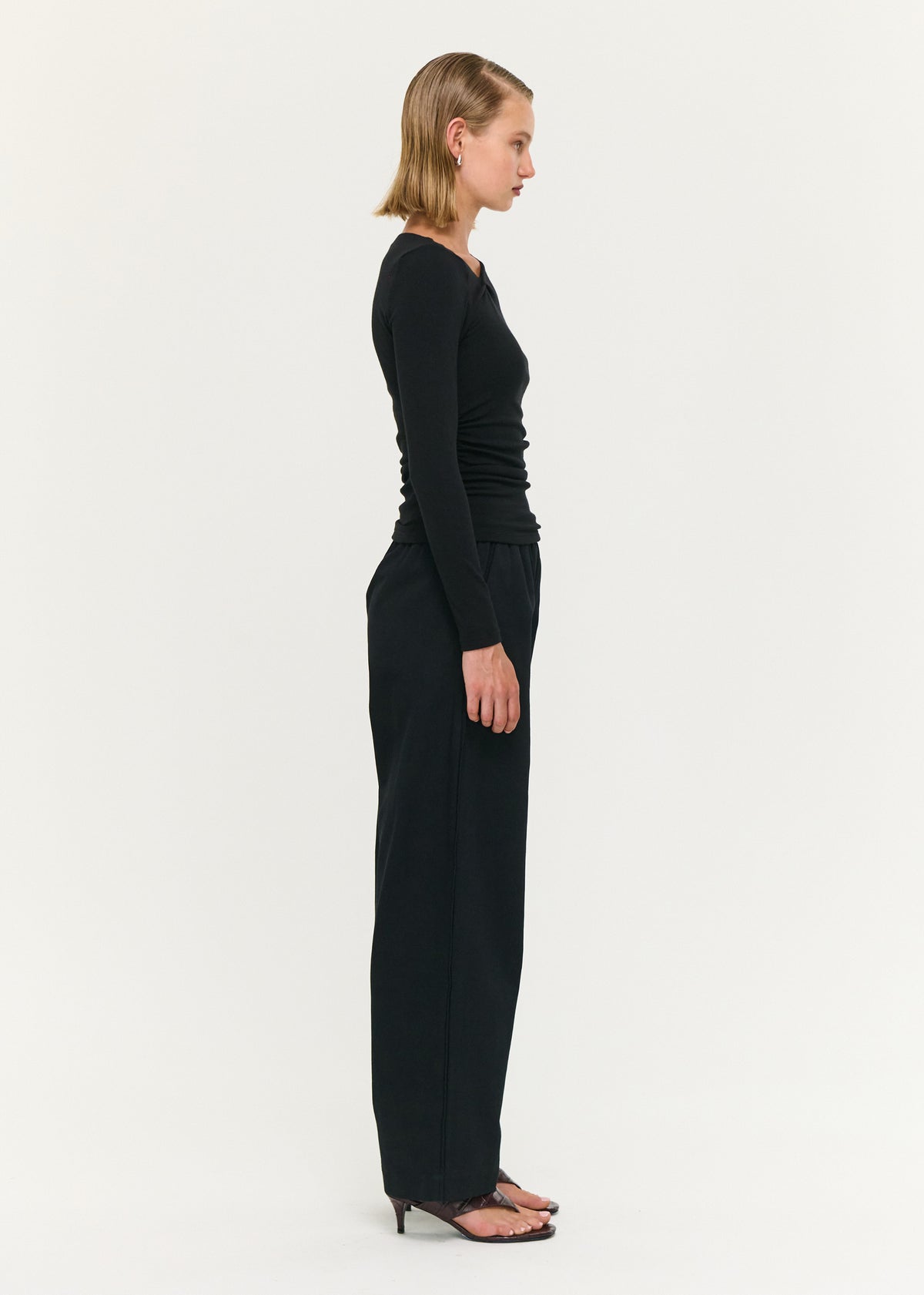Side view of the Black Soft Jersey Twist Neck Top, showing a soft stretch fabrication and a fitted silhouette.