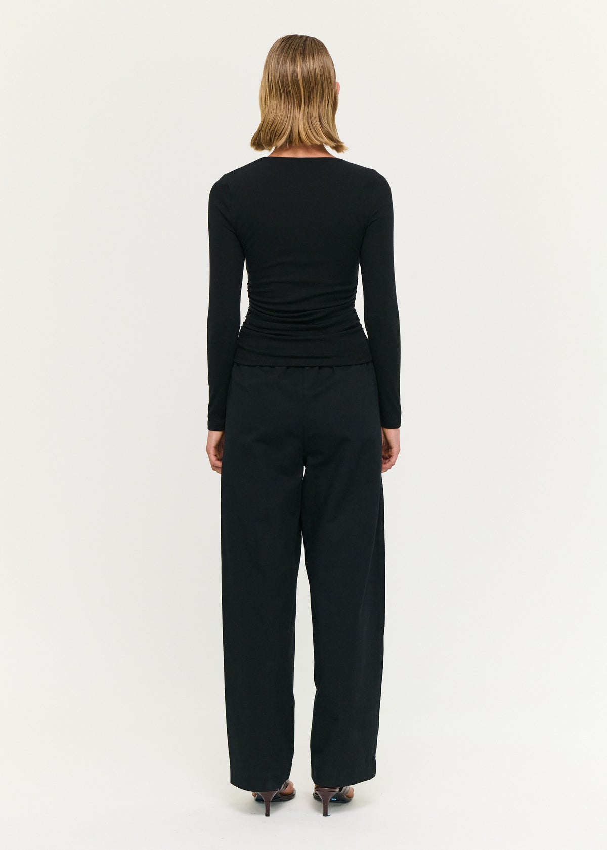 Back view of the Black Soft Jersey Twist Neck Top with a soft stretch fabrication and a fitted silhouette.