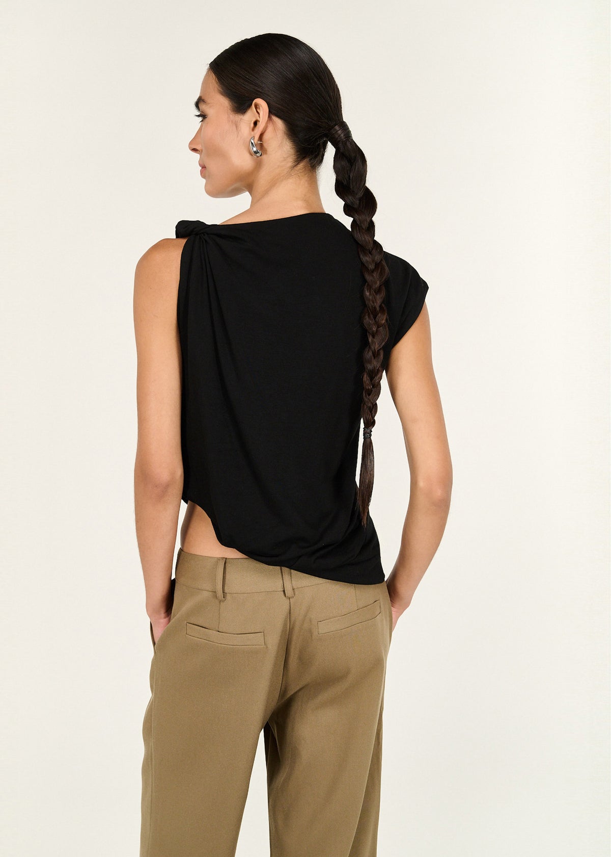 Back view of the Black Twist Asymmetric Tank with a soft stretch fabrication and a high neckline.