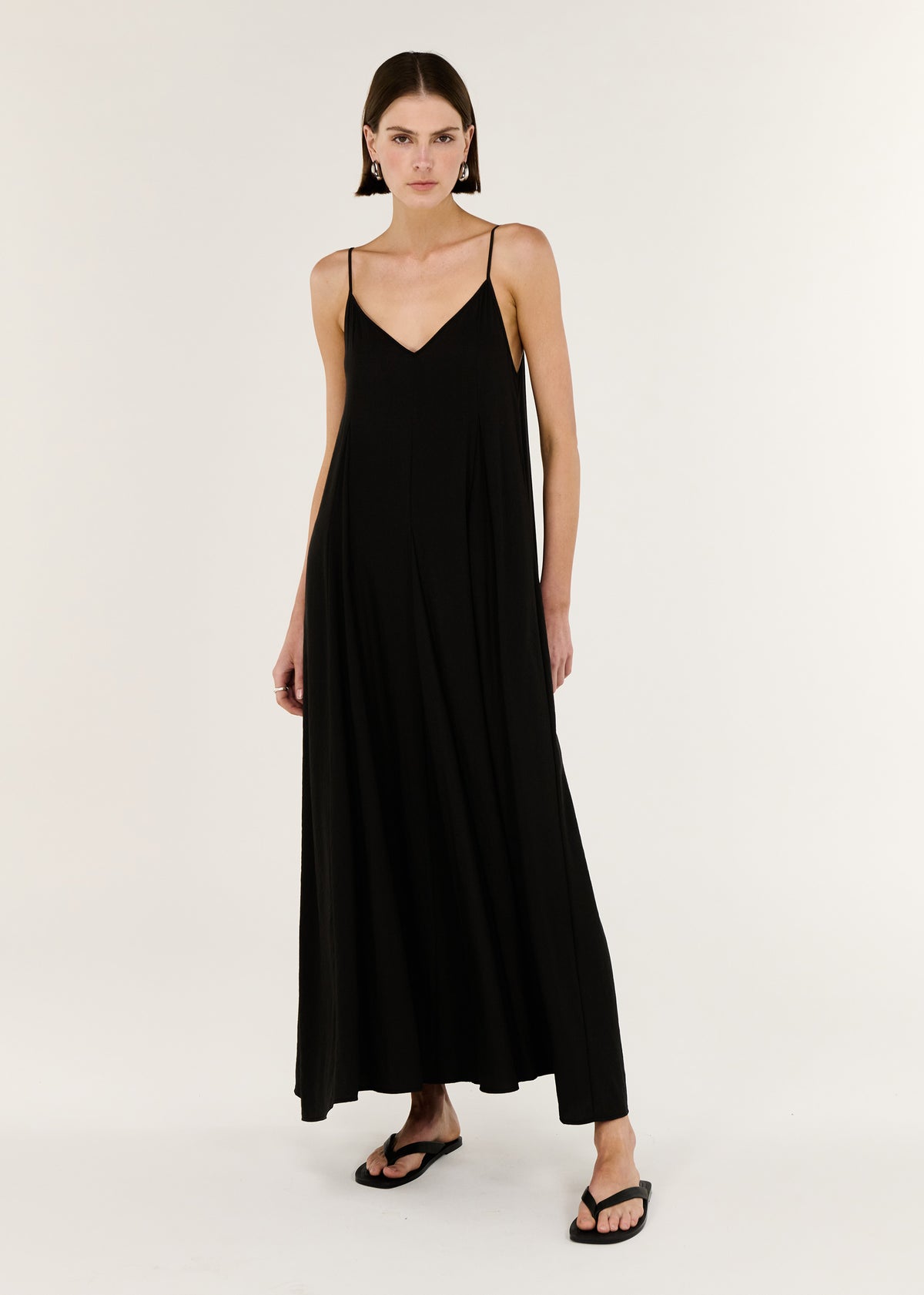 Model wearing Black V-Neck Floaty Maxi Dress with a maxi length silhouette and a deep V neckline.