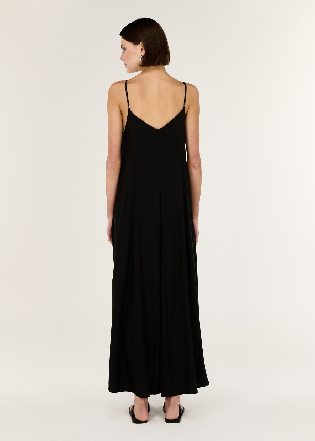 Back view of the Black V-Neck Floaty Maxi Dress with thin adjustable straps and a maxi length silhouette.