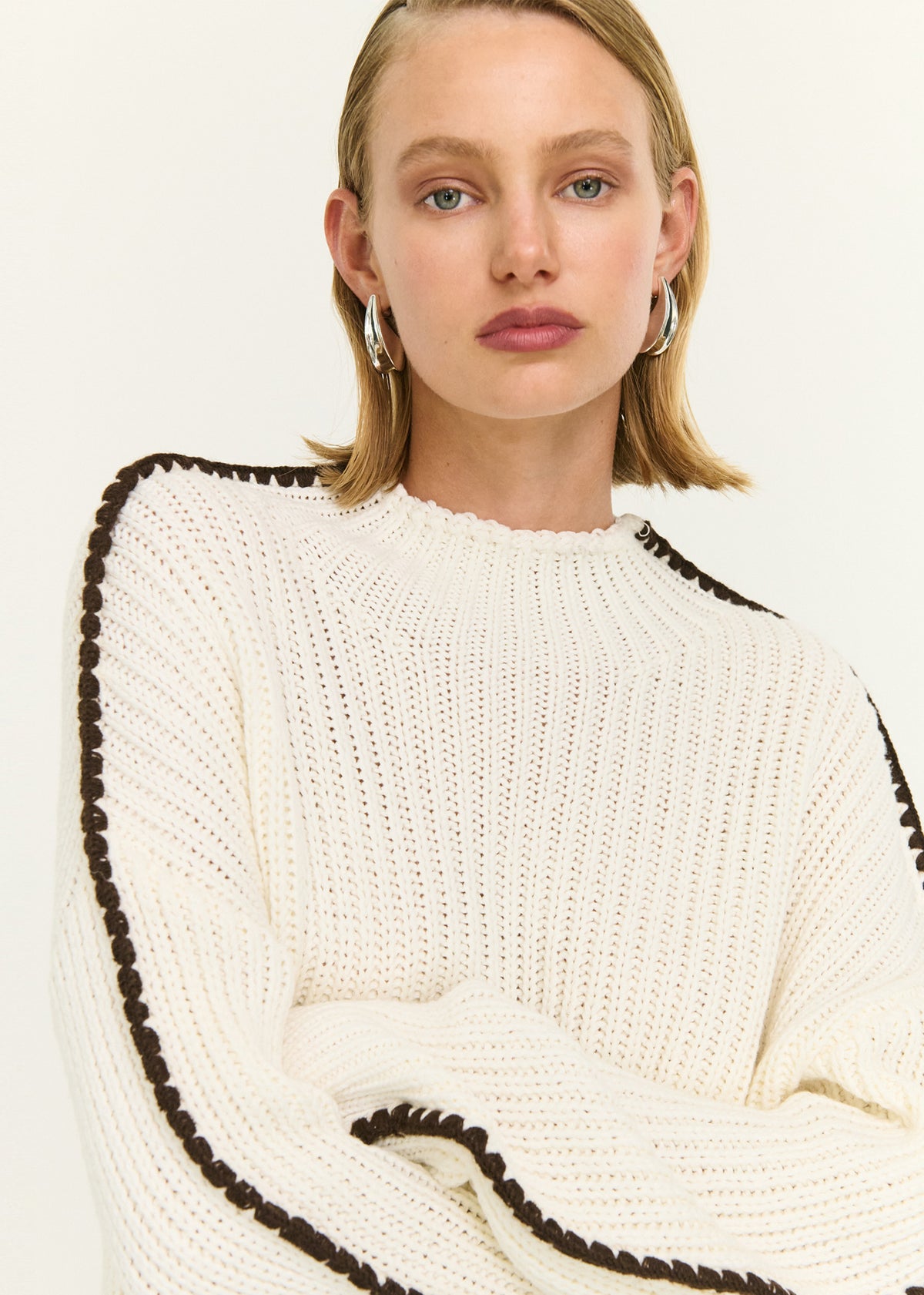 Close-up of the Blanket Stitch Detail High Neck Jumper, showing a high neckline and a dropped shoulder design.