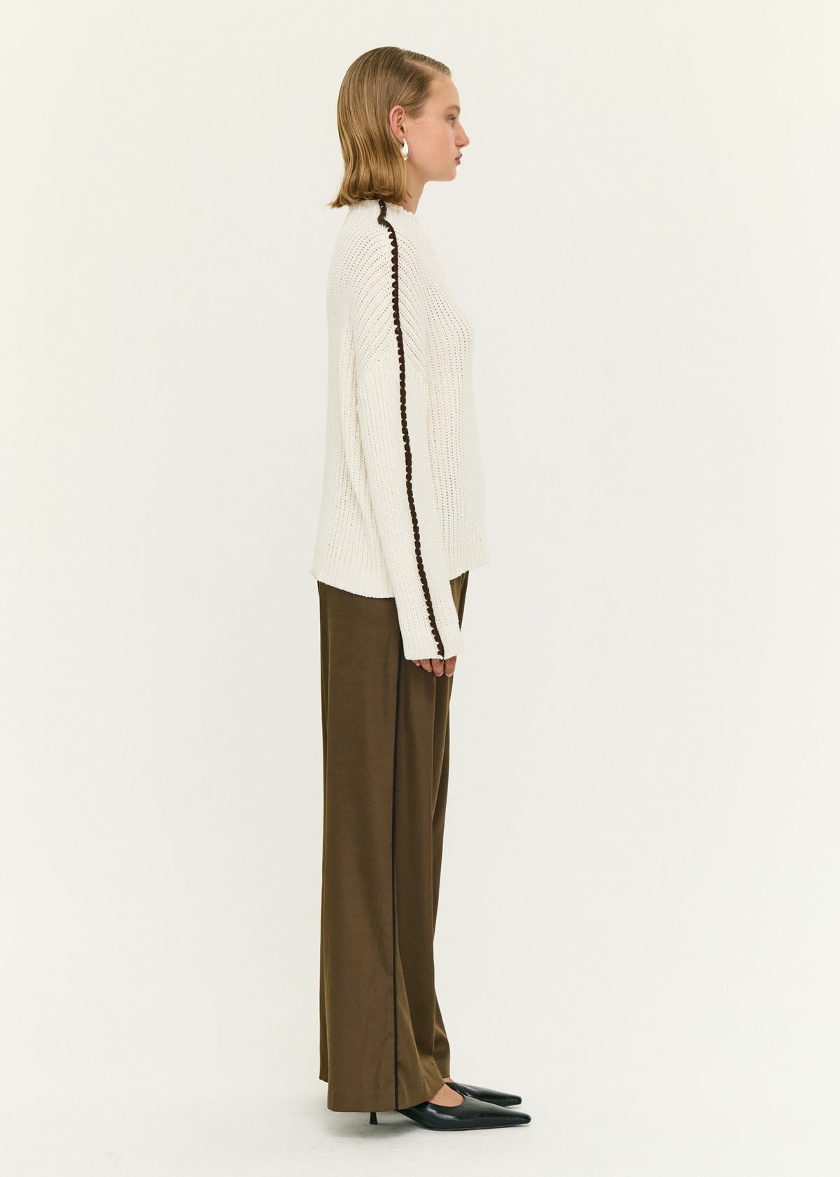 Side view of the Blanket Stitch Detail High Neck Jumper, showing ribbed hem and cuffs.