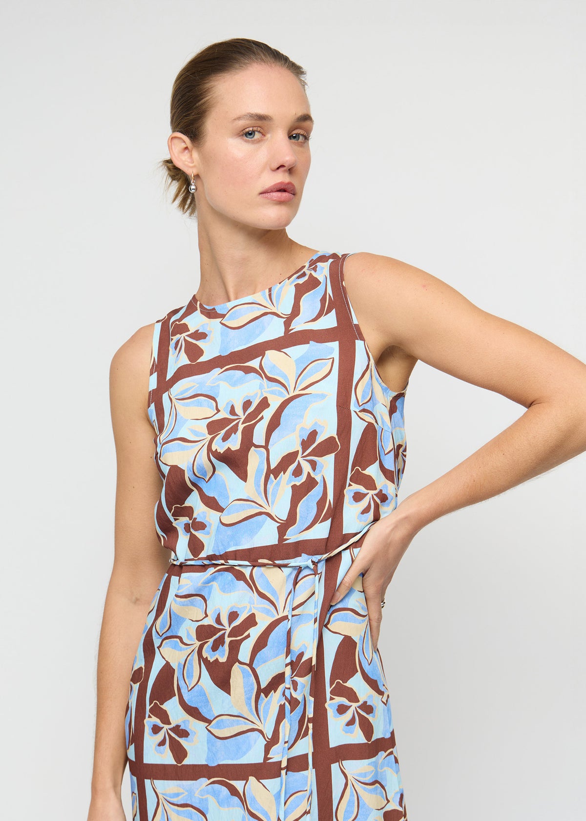 Close-up of the Blue Abstract floral Midi Dress with Tie Waist, showing a sleeveless, high-neck silhouette and a midi length.