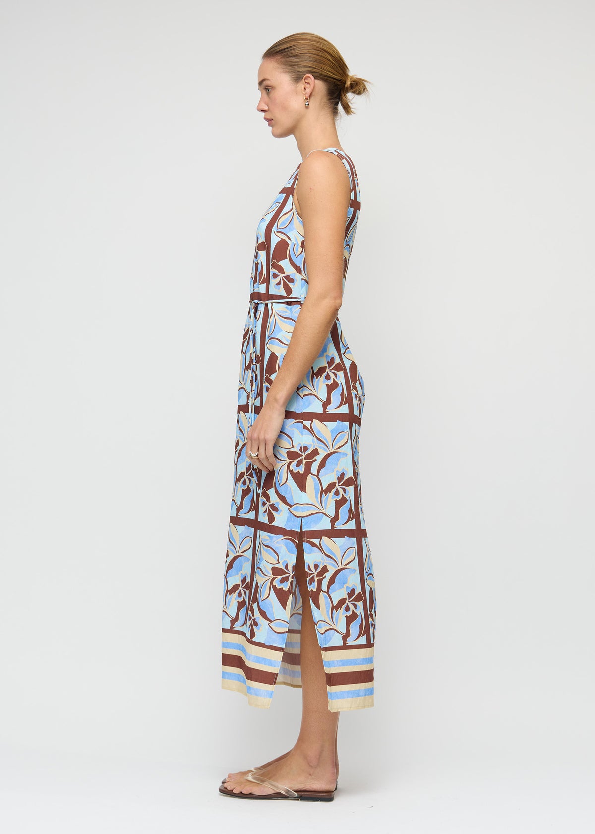 Side view of the Blue Abstract floral Midi Dress with Tie Waist, showing a sleeveless, high-neck silhouette and a midi length.