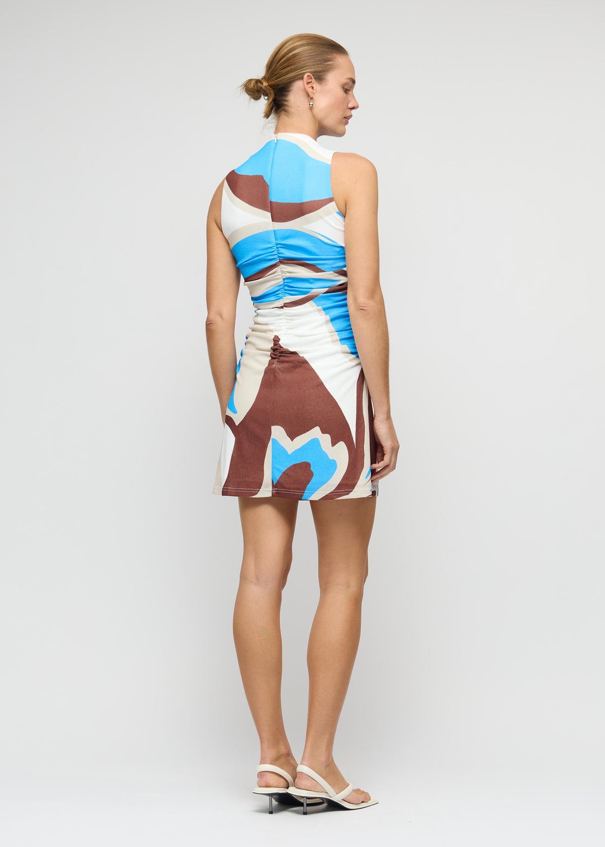 Model wearing Blue Abstract Mesh Mini Dress with a mini length with a subtle A-line hem, turned to the side.
