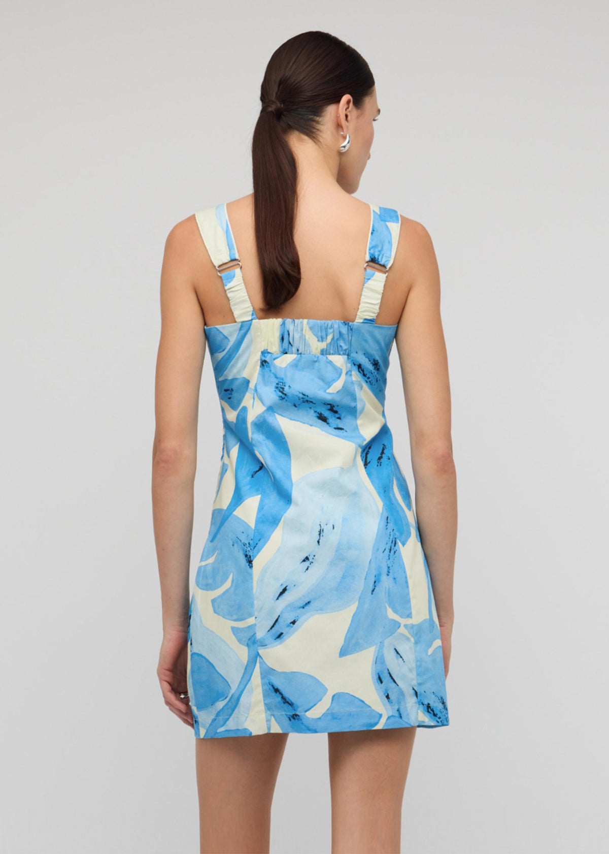 Back view of the Blue and White Floral Cotton Mini Dress with square neckline with wide straps and a mini length.