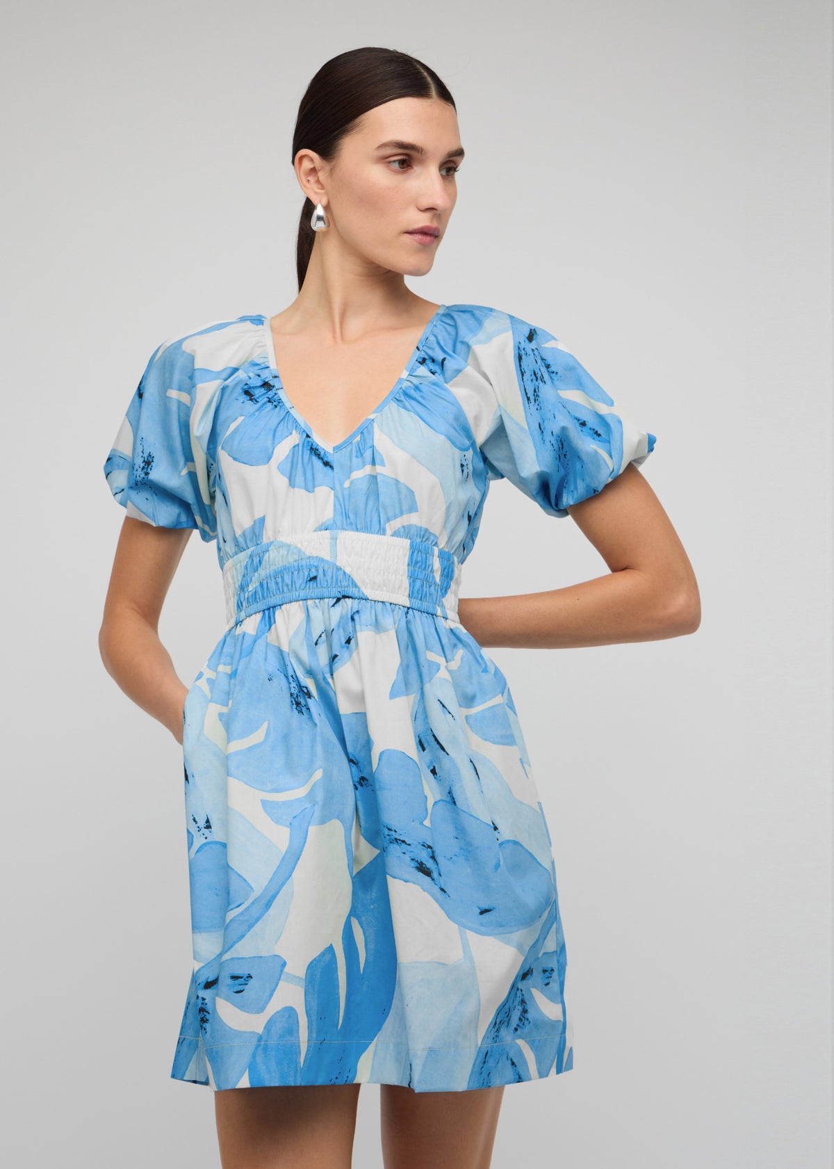 Close-up of the Blue and White Floral Cotton V-Neck Mini Dress, showing v-neckline with puff sleeves.