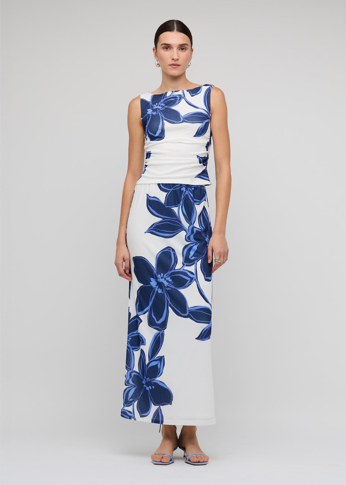 Model wearing Blue and White Floral Mesh Top with a side ruching detail and a stretch fit, fully lined.