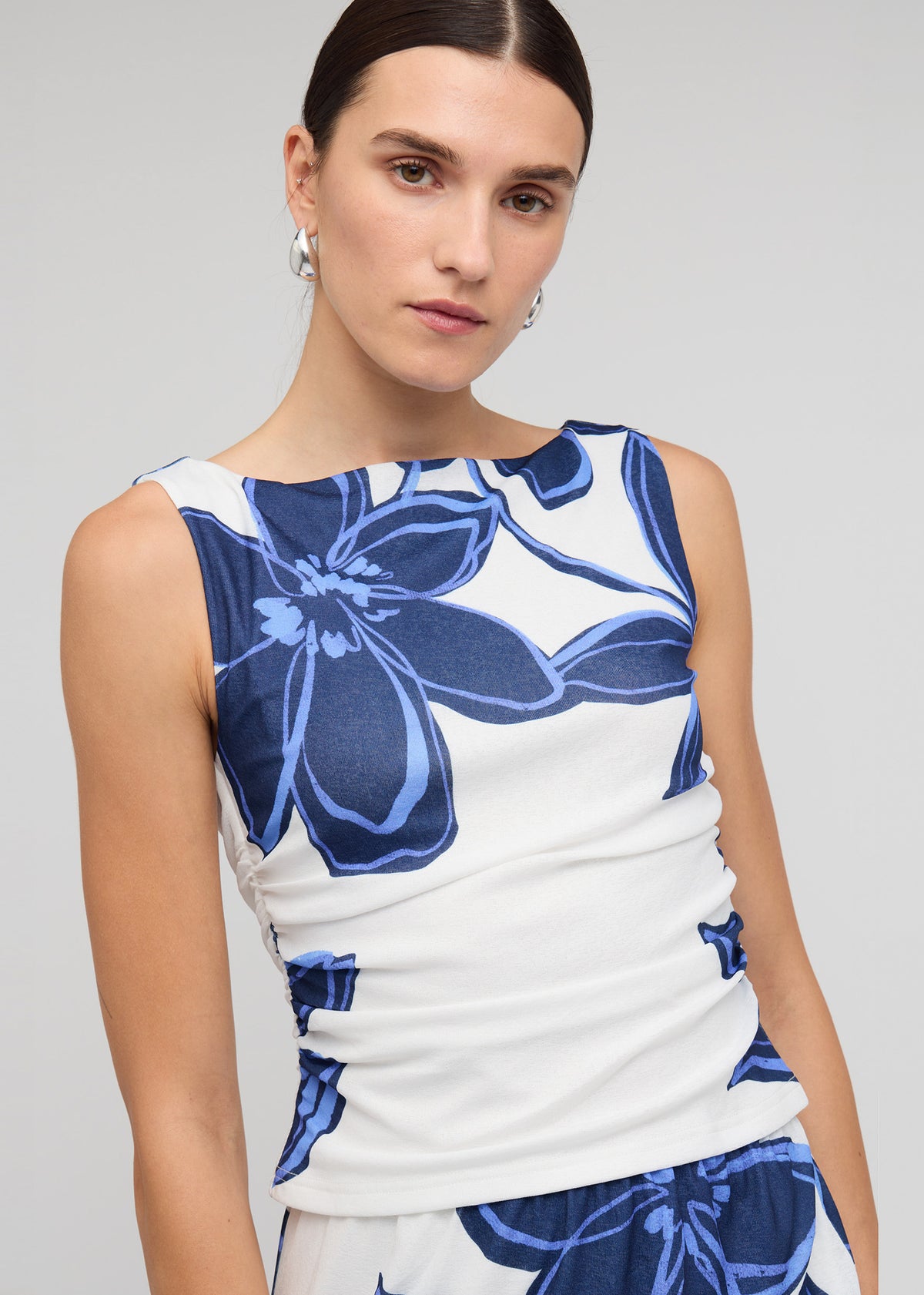 Close-up of Blue and White Floral Mesh Top with a sleeveless tank silhouette and a blue floral mesh print.