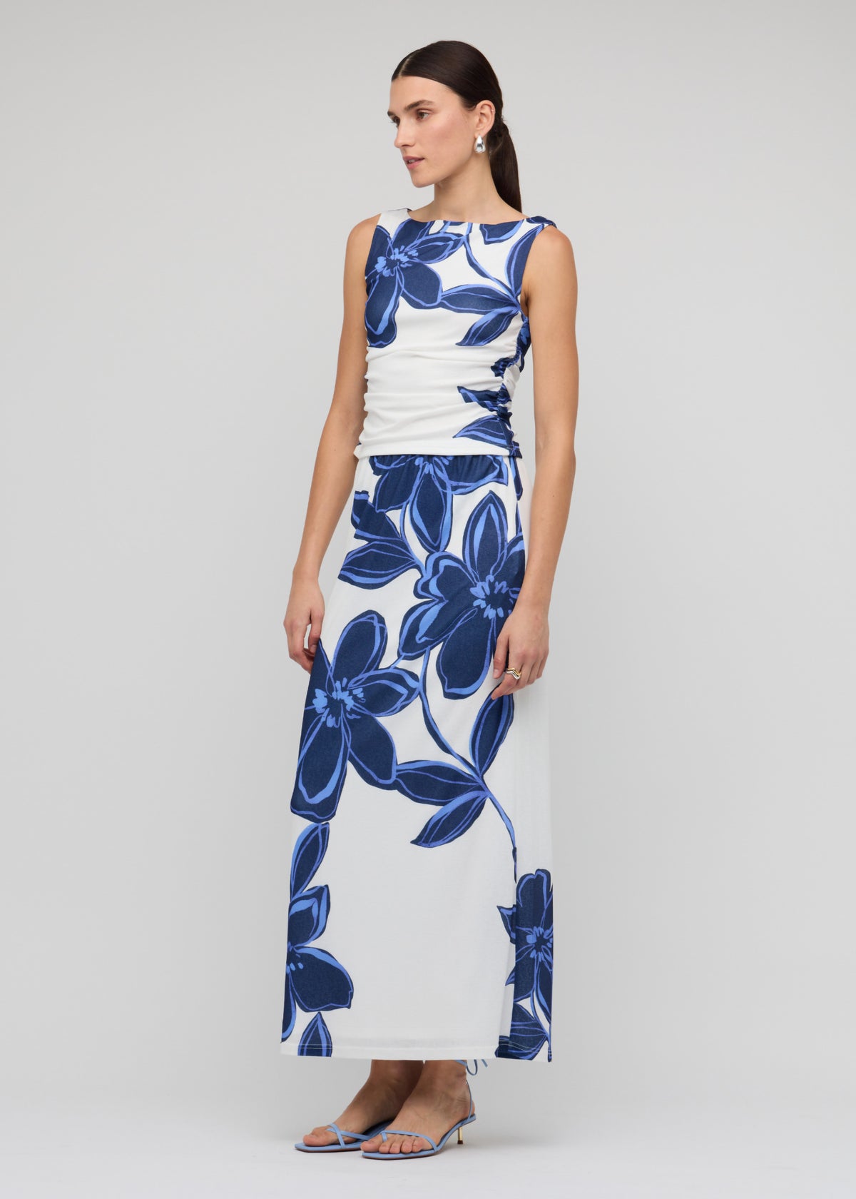 Model wearing Blue and White Floral Mesh Top, showing a side ruching detail and a stretch fit, fully lined.