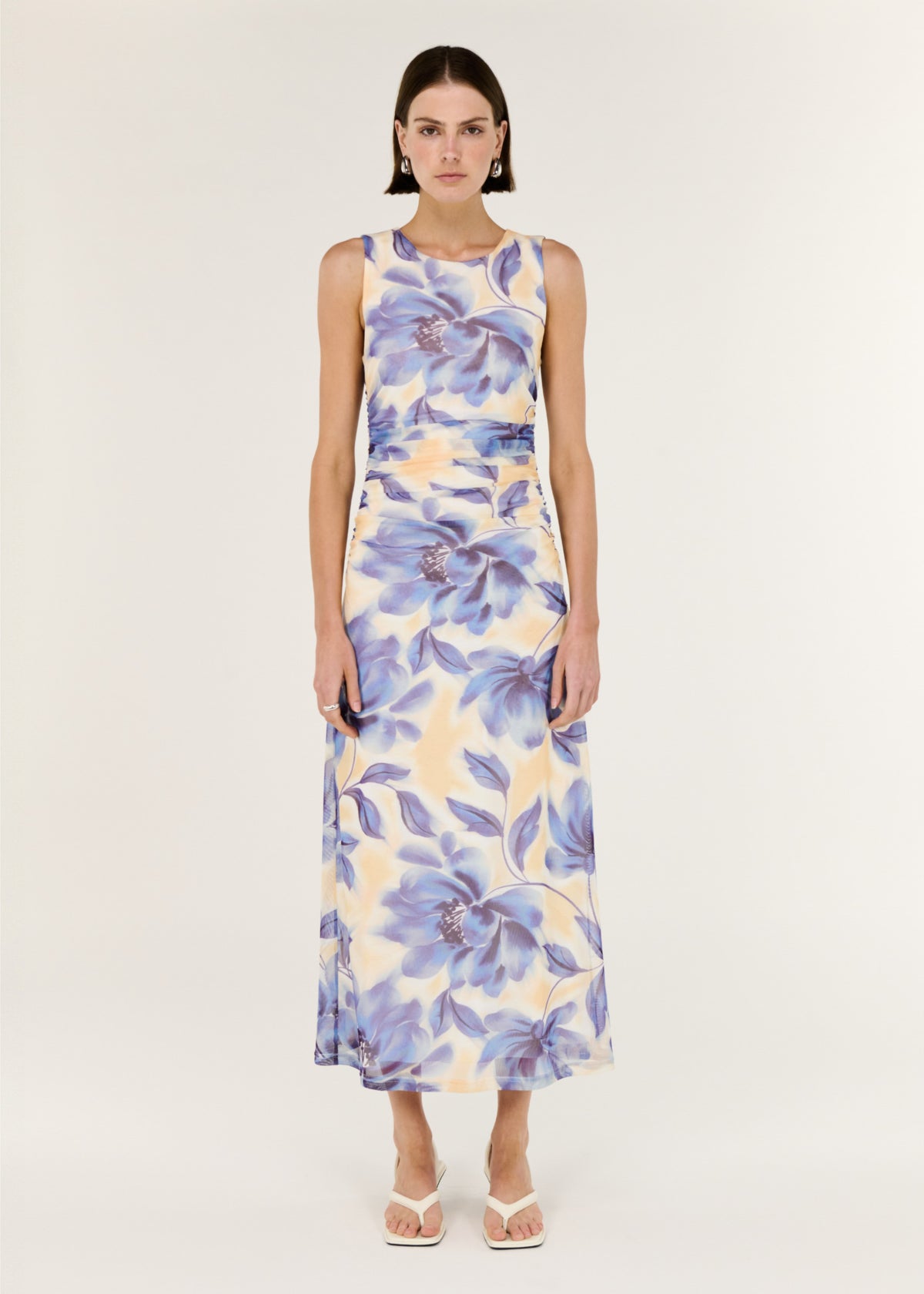 Model wearing Blue Blurred Floral Mesh Midi Dress with a sleeveless cut and a stretch mesh fabrication.