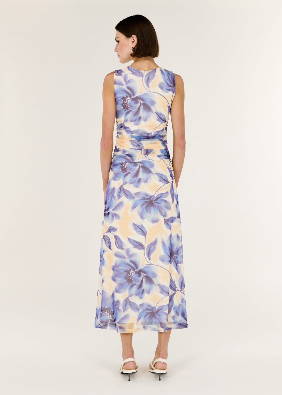 Back view of the Blue Blurred Floral Mesh Midi Dress with a sleeveless cut and a stretch mesh fabrication.