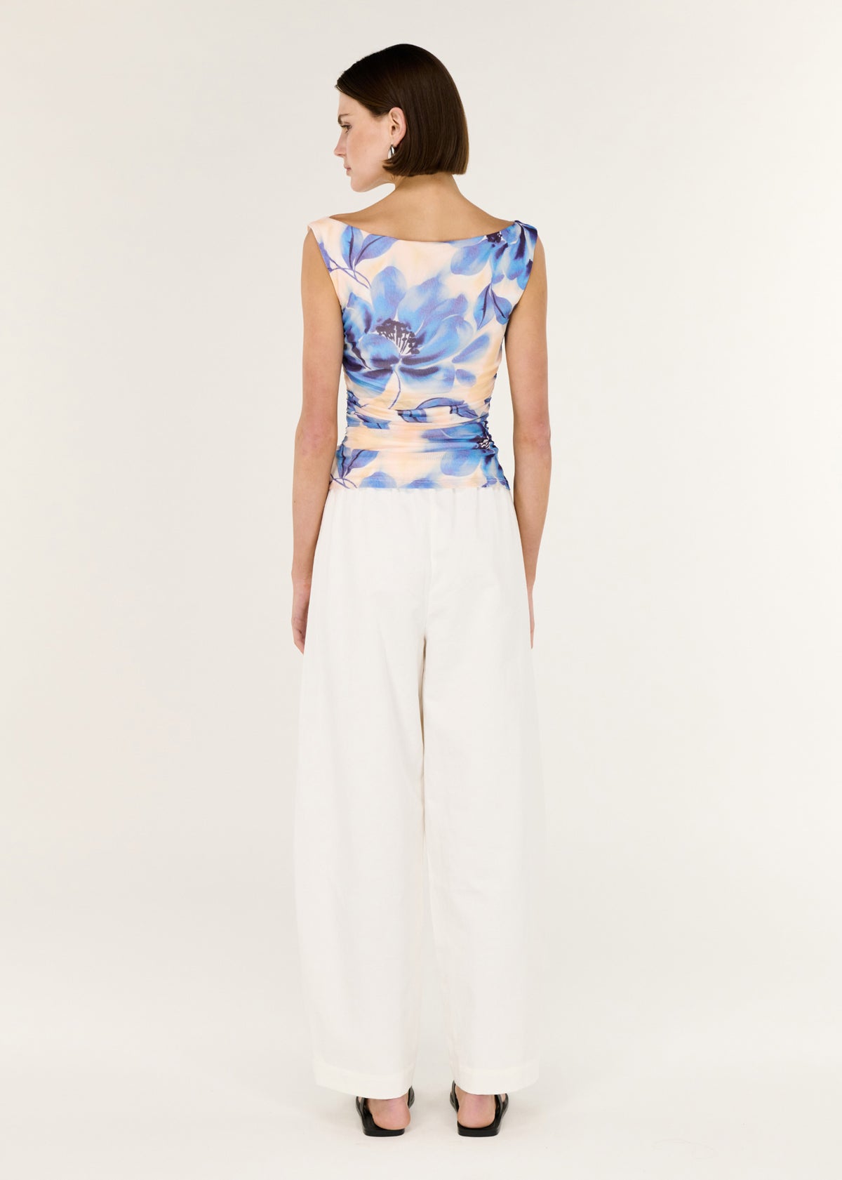 Back view of the Blue Blurred Floral Mesh Top with a sleeveless cut and a stretch fabrication.