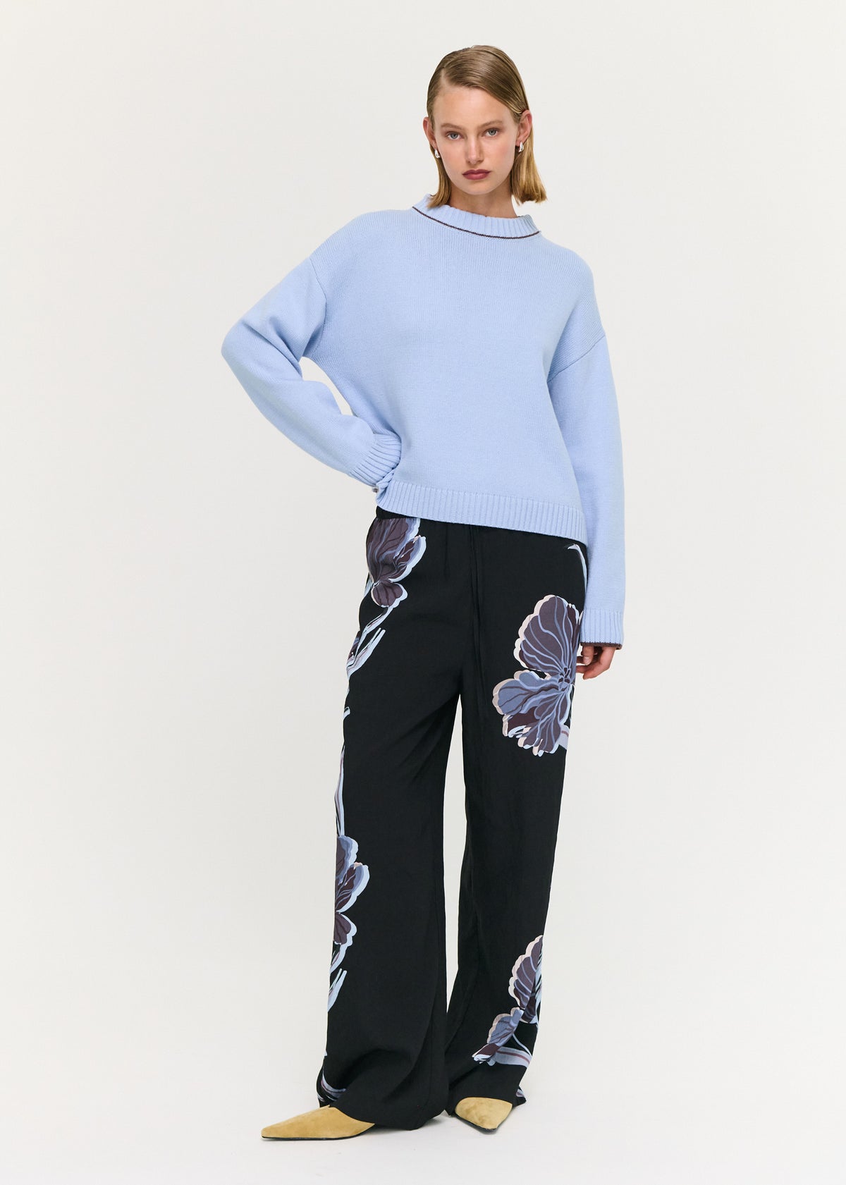 Model seated wearing Blue Cotton Blend Contrast Seam Jumper with a ribbed hem and a slight cropped length.