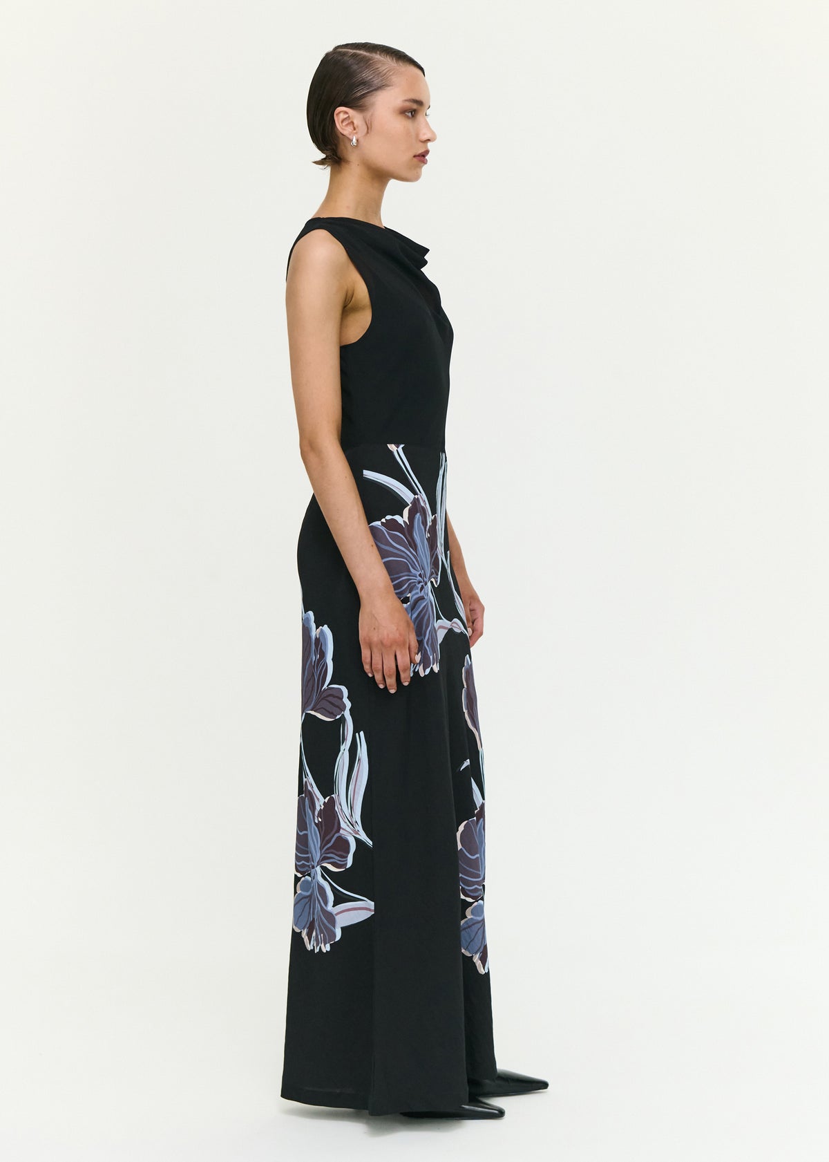 Model wearing Blue Floral Bias Cut Combo Midi Dress with a fitted through the bodice and a midnight floral print, turned to the side.