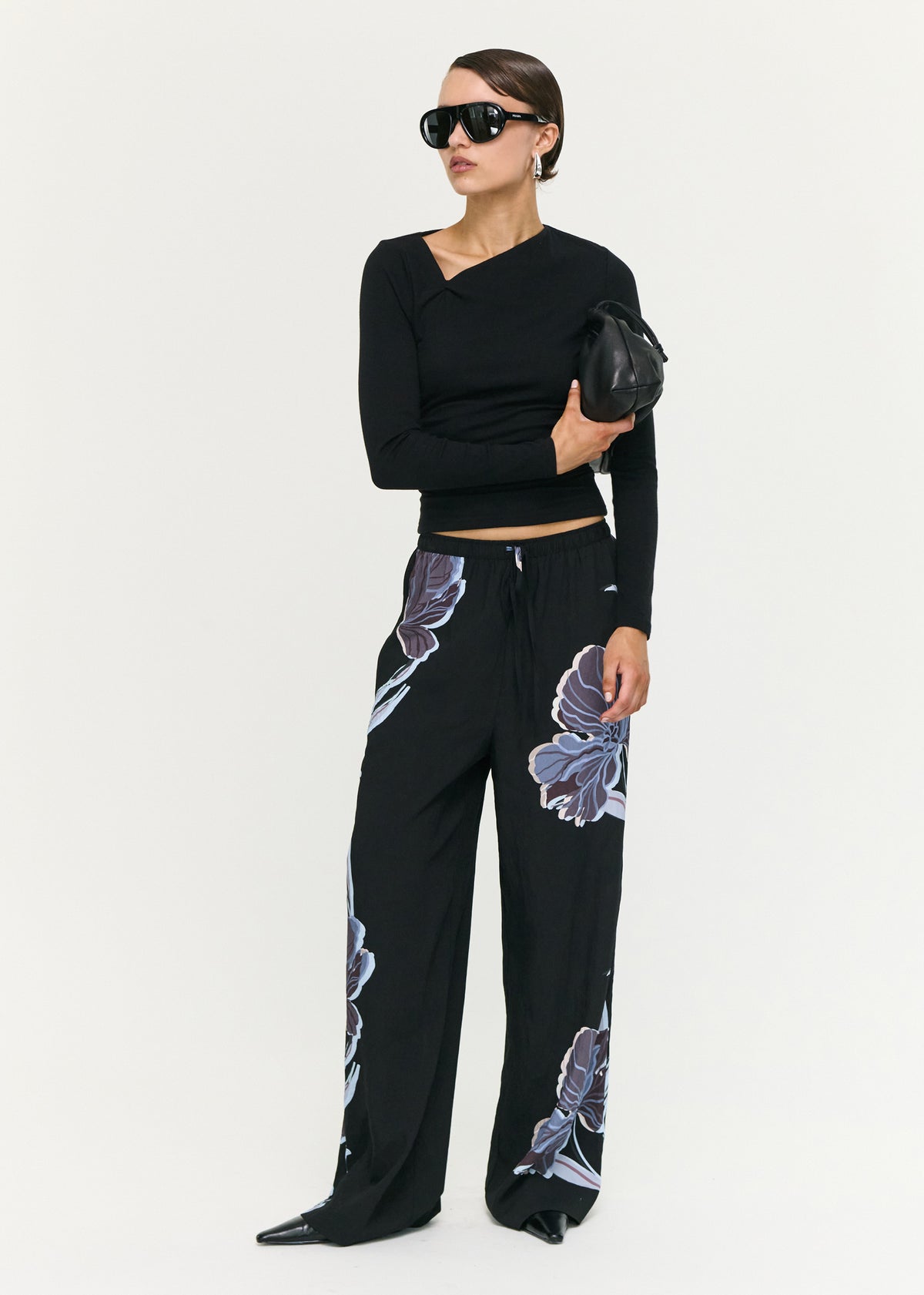 Model wearing Blue Floral Relaxed Drawstring Pant with a full length and a midnight floral print, turned to the side.